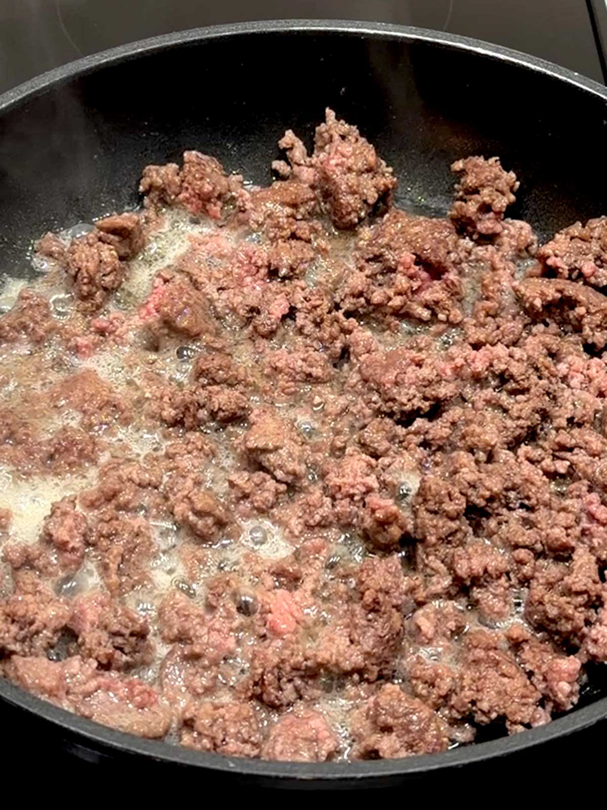 Cooking ground beef in a large skillet.