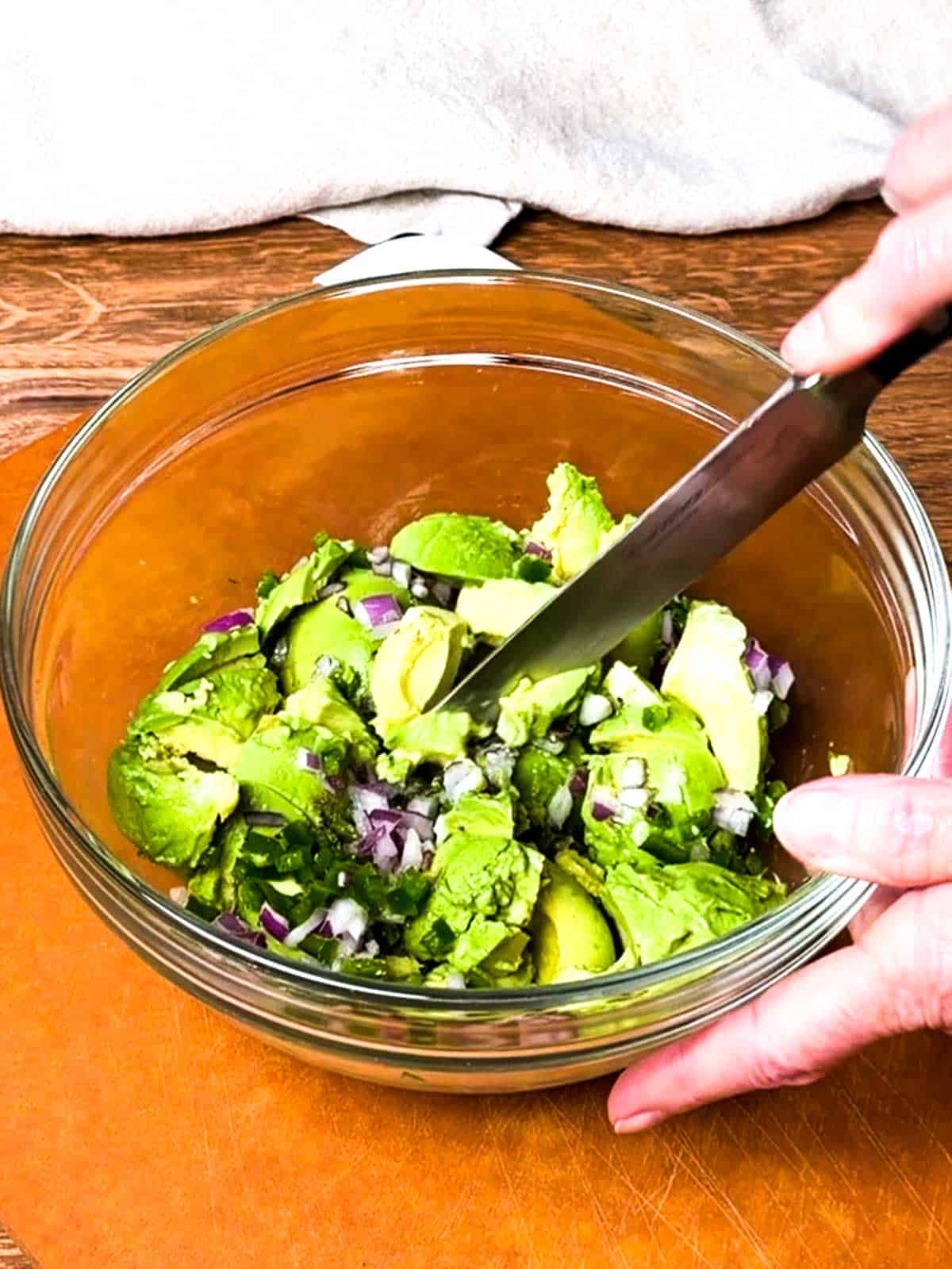 Cutting avocado mixture with a knife.
