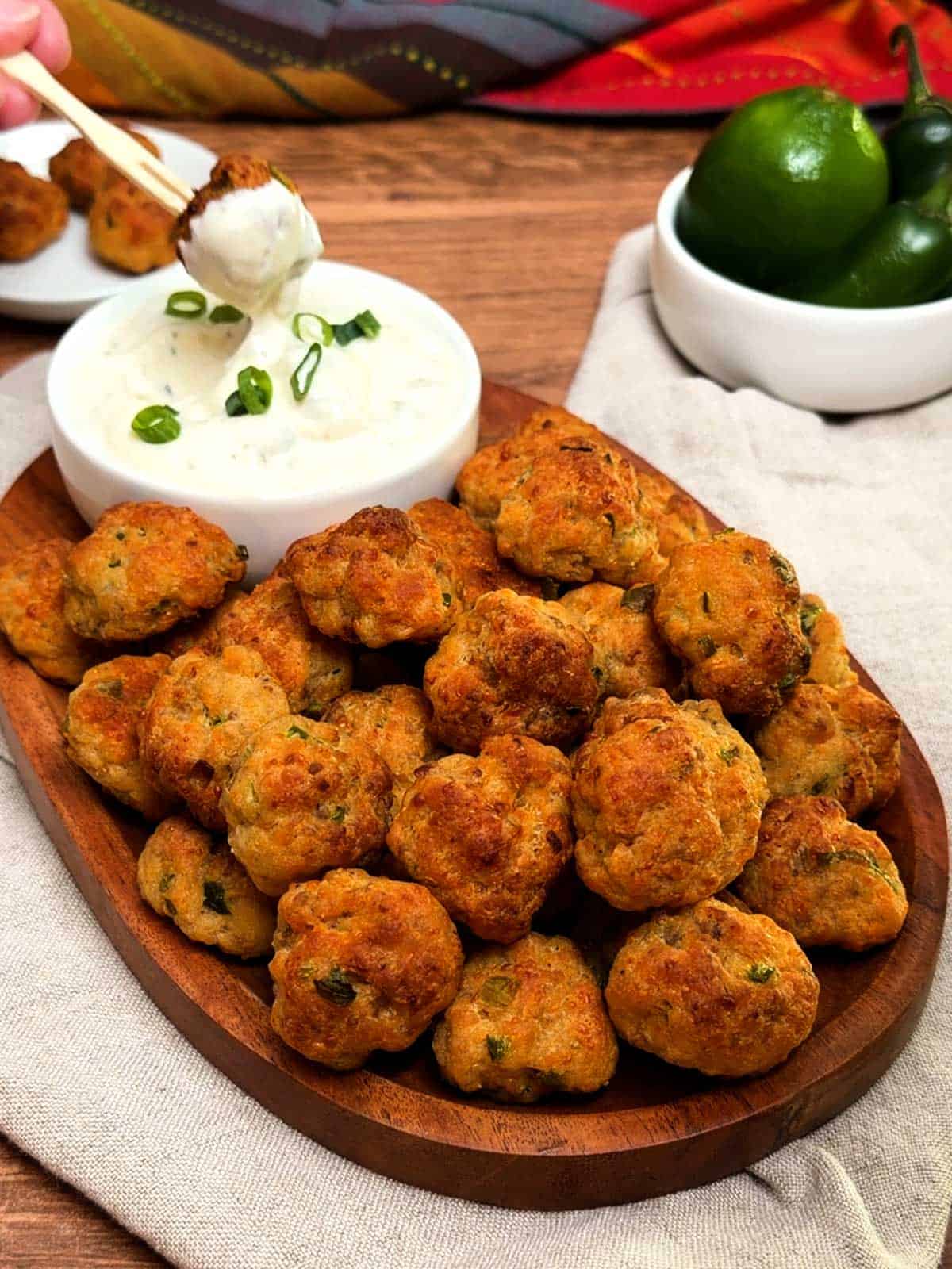 Dipping sausage balls in ranch dipping sauce.
