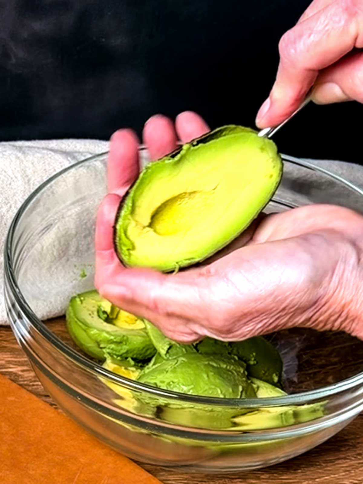 Scooping the avocado into a bowl.