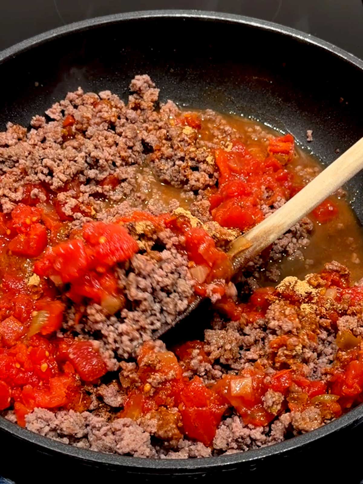 Stirring the seasoned taco meat.