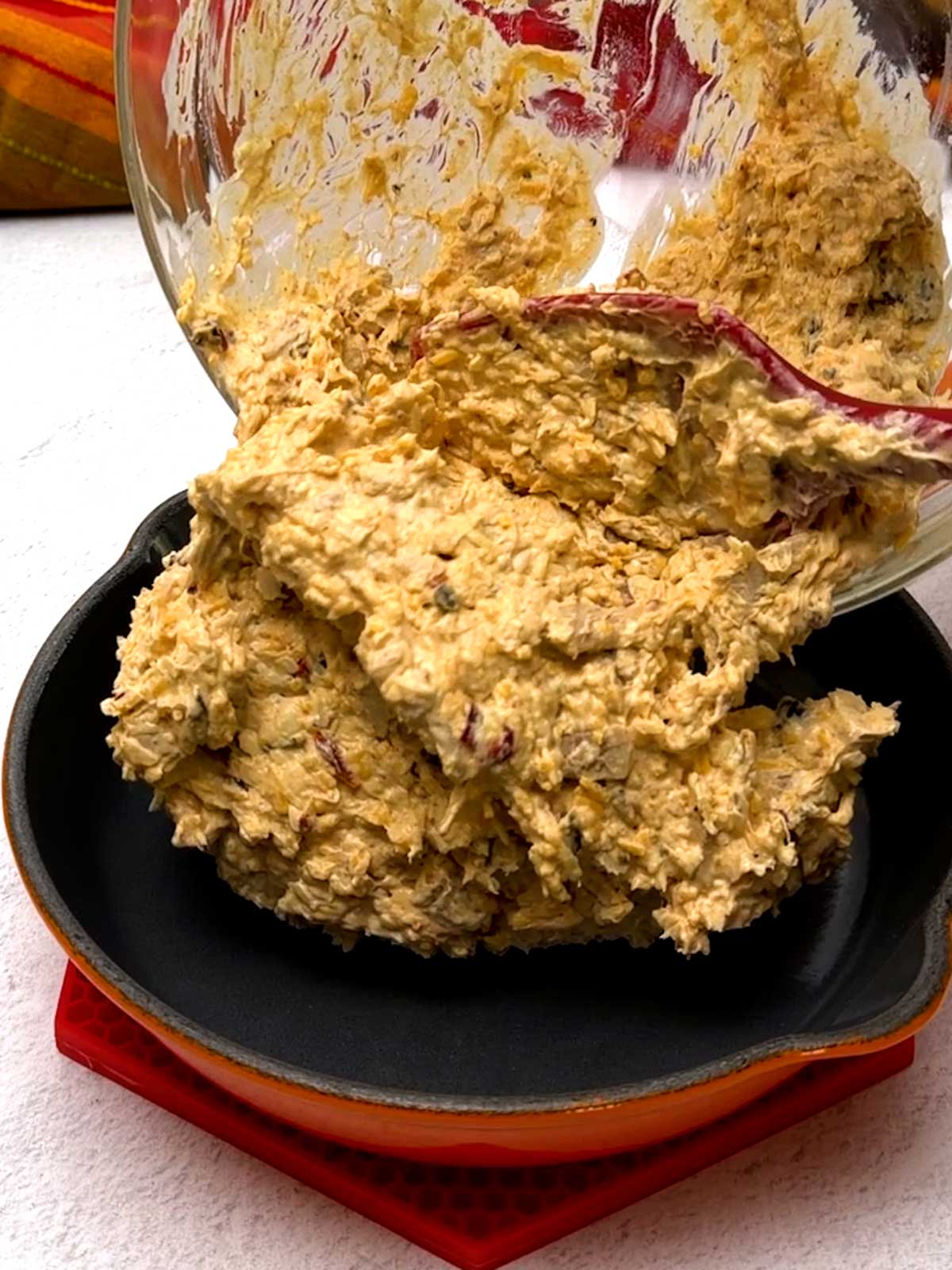 Transferring the tip mixture to a 7.5 inch Le Creuset cast-iron pan.
