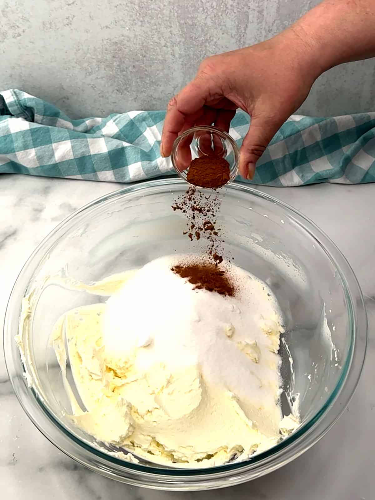adding sugar and cinnamon to beaten cream cheese