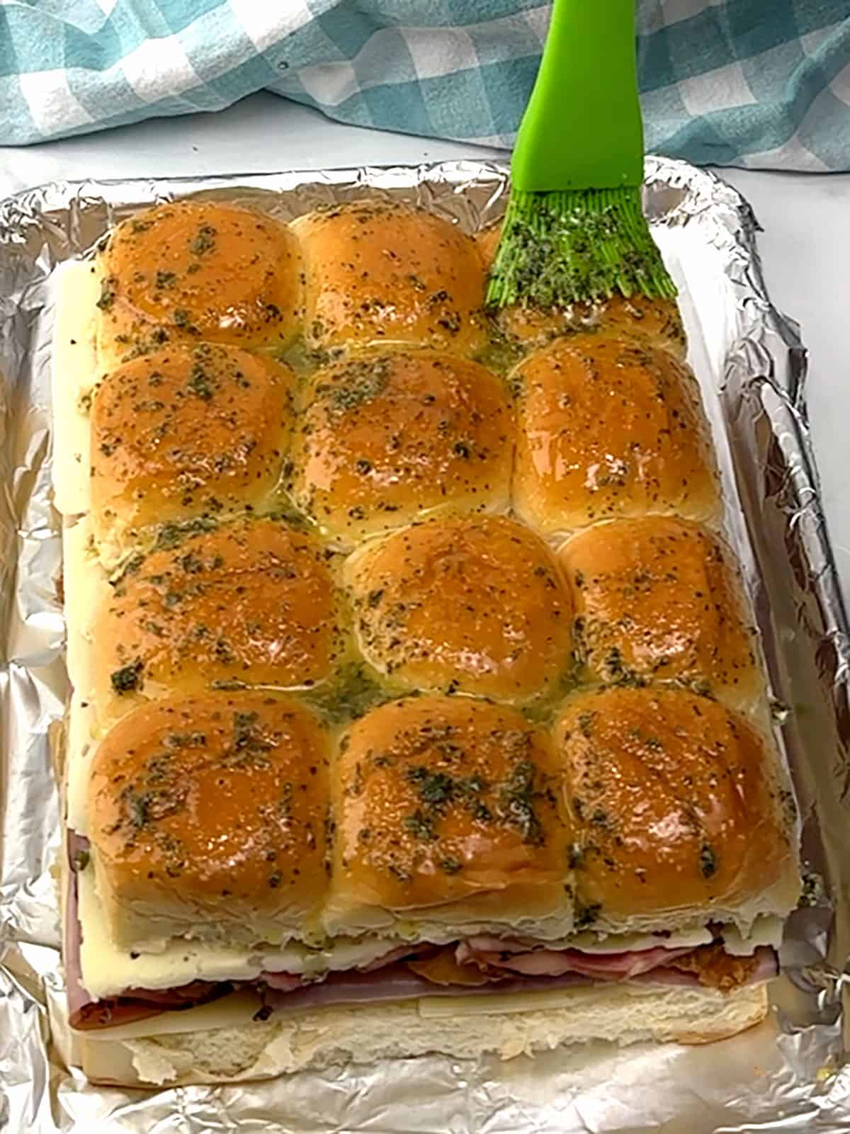 brushing butter on top of sliders