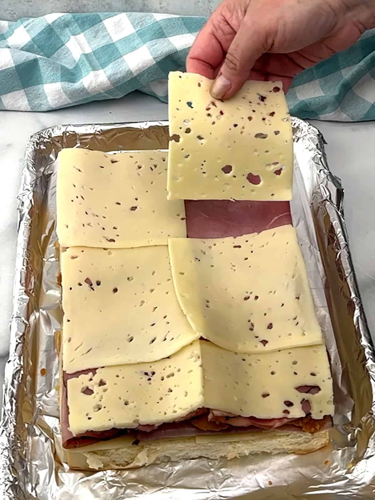 placing cheese on top of ham