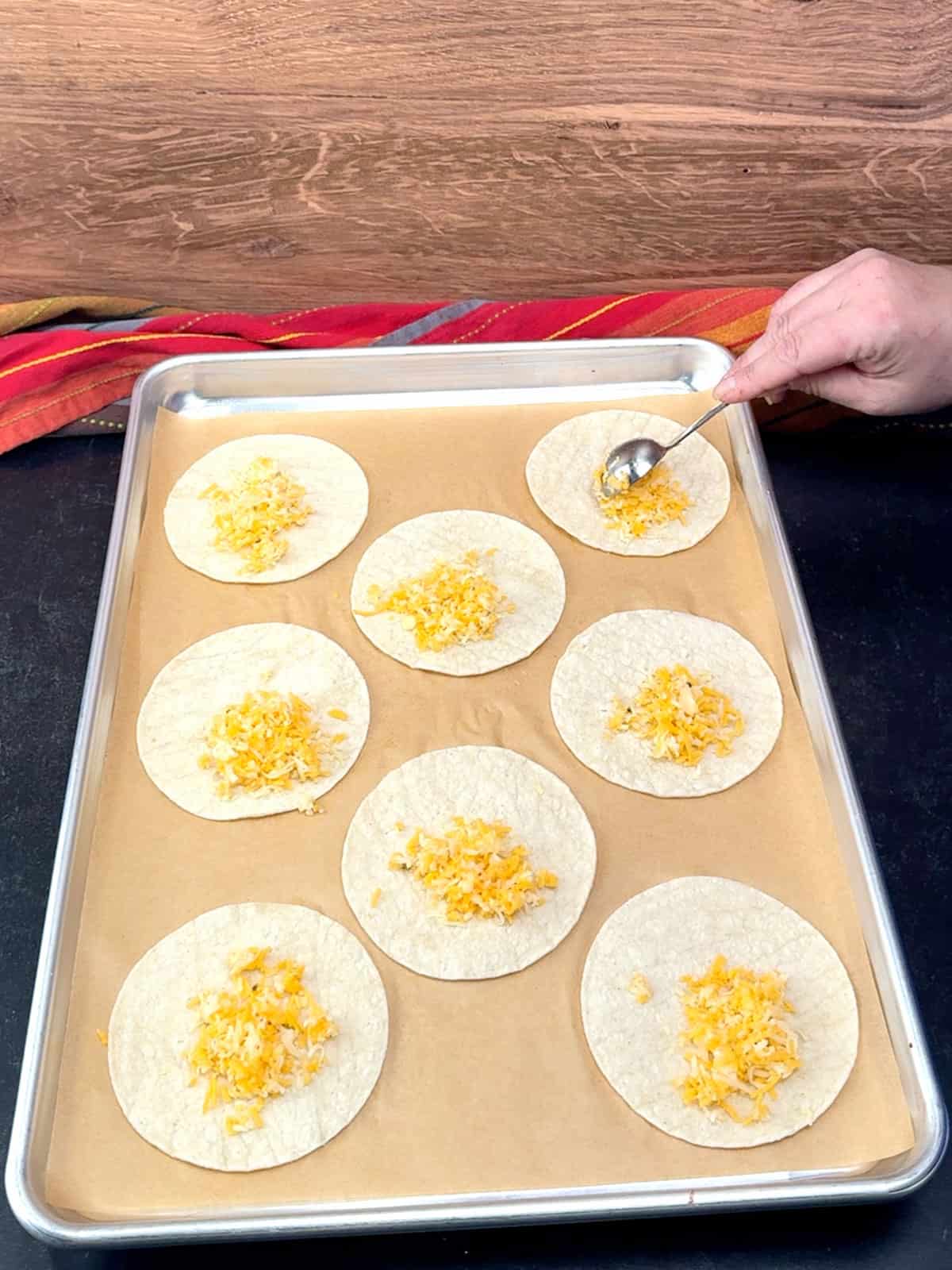 sprinkling cheese on tortillas