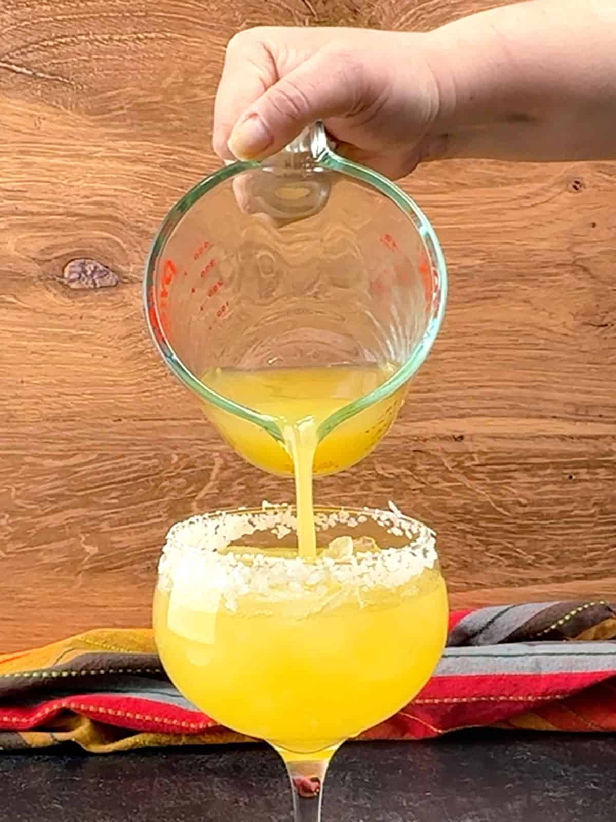 filling glass with margarita mocktail