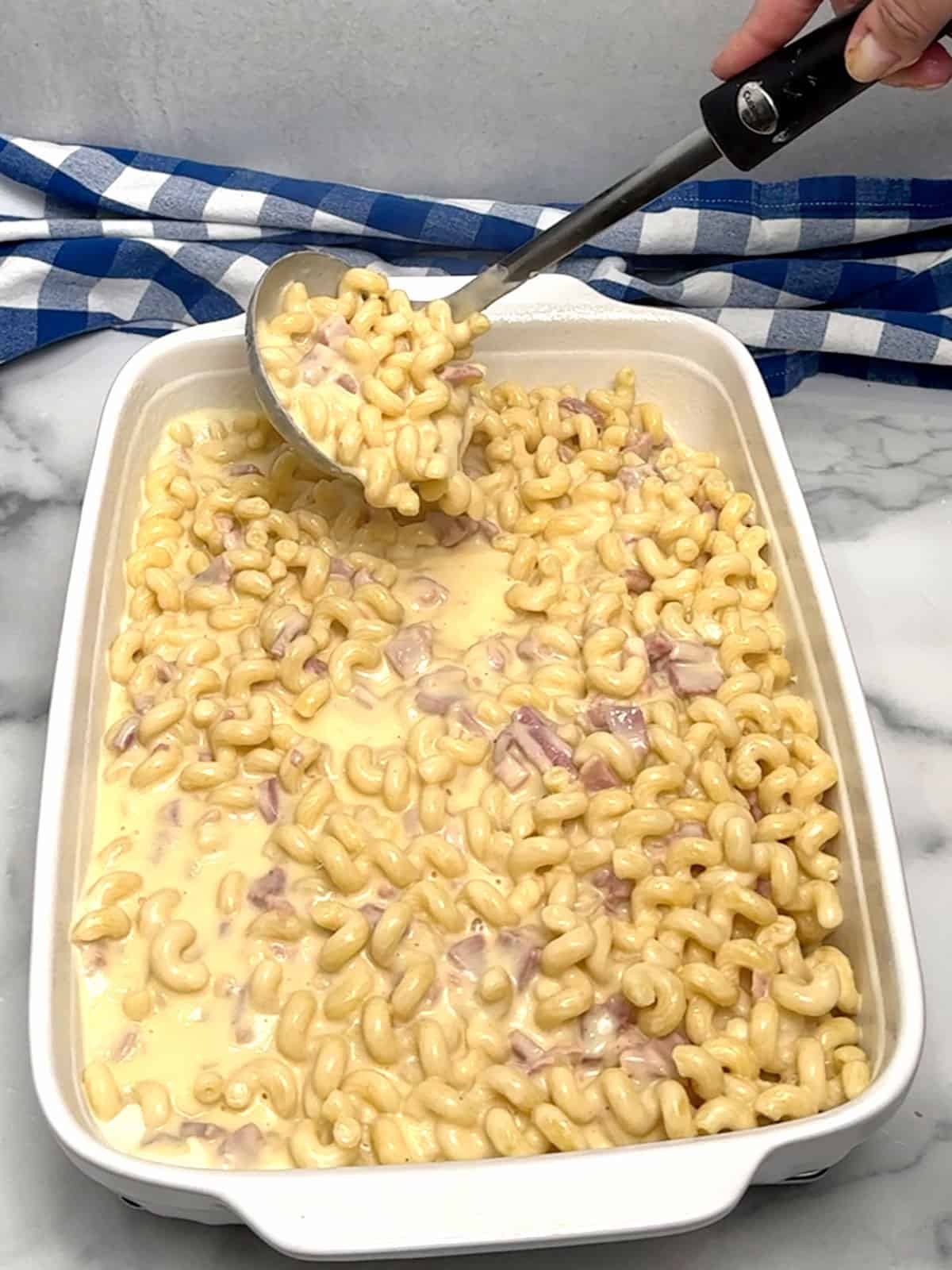 filling baking dish with pasta mixture