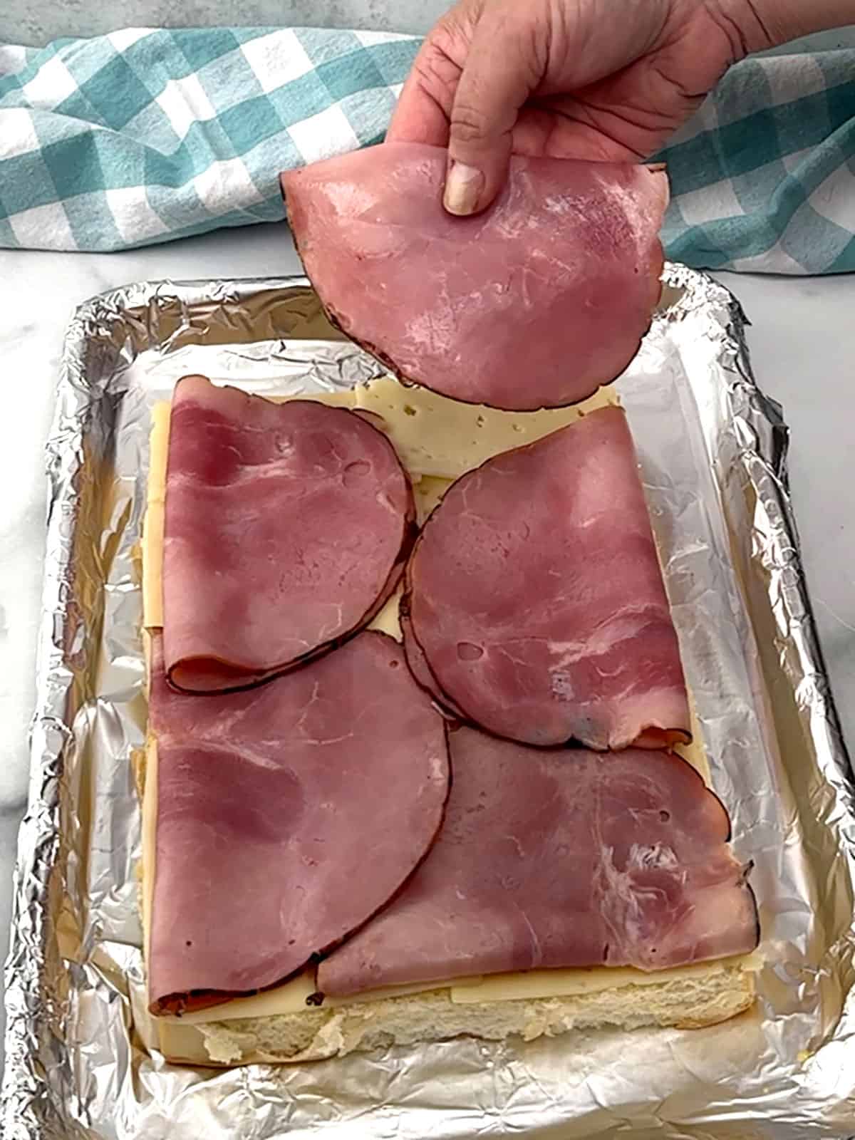 placing ham on top of cheese slices