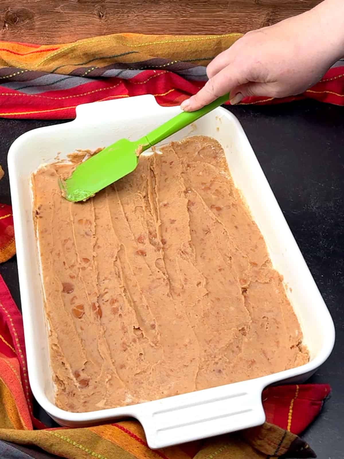 spreading beans into bottom of baking dish