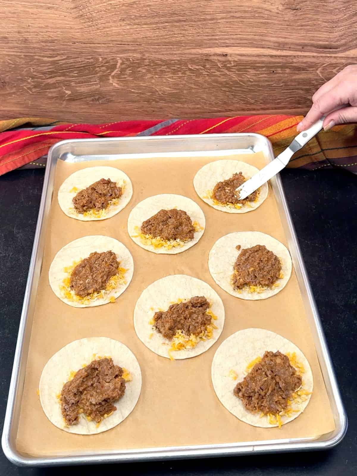 spreading meat mixture over tortillas