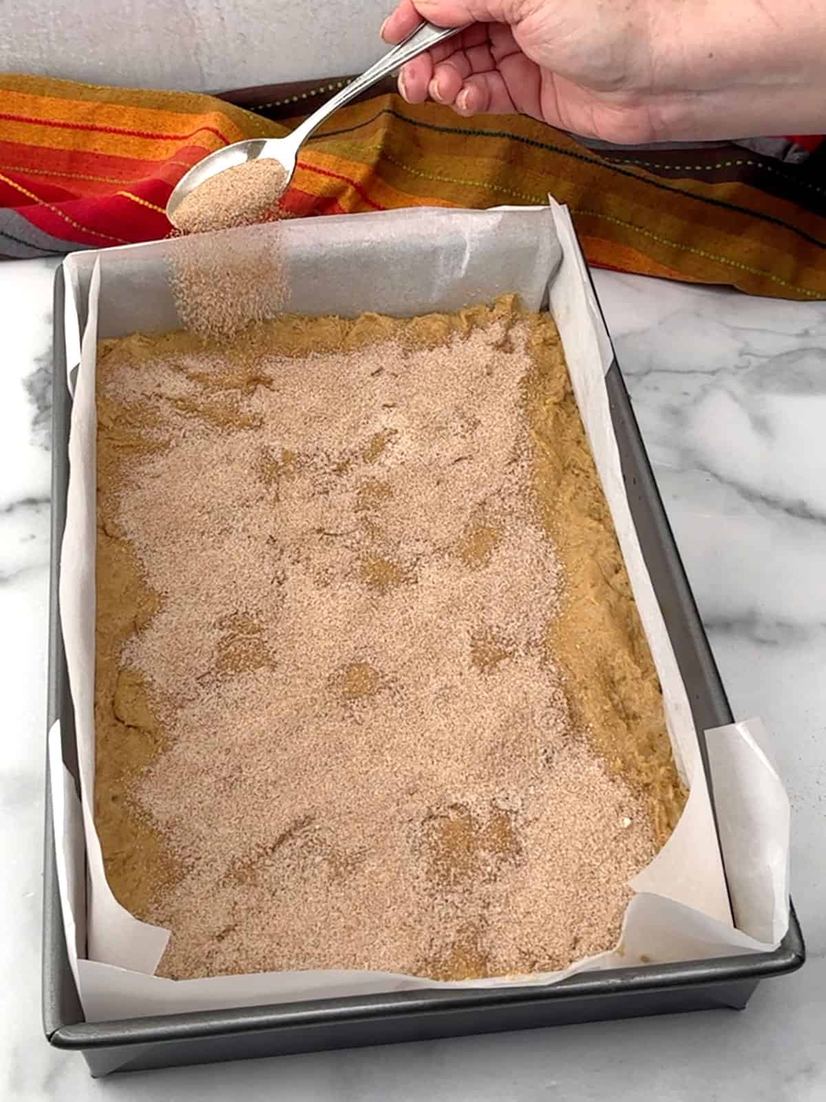 sprinkling cinnamon-sugar mixture over the top of the churro blondie dough