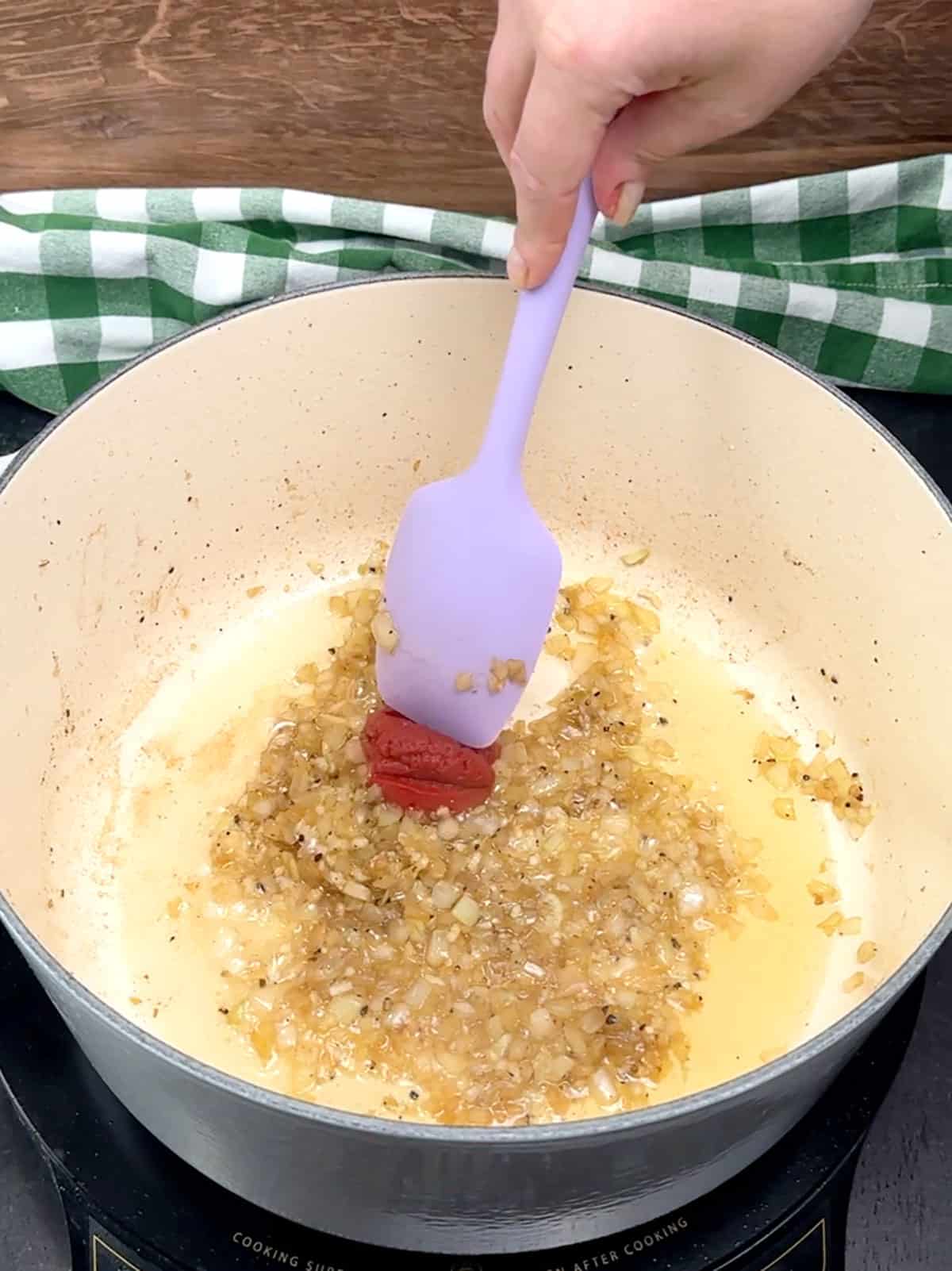 stirring tomato paste into sautéed onions and garlic