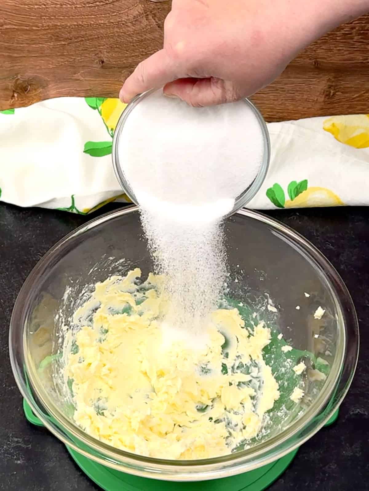 adding granulated sugar to beaten butter
