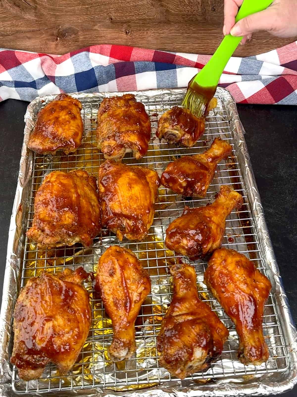 brushing chicken pieces with first round of BBQ sauce