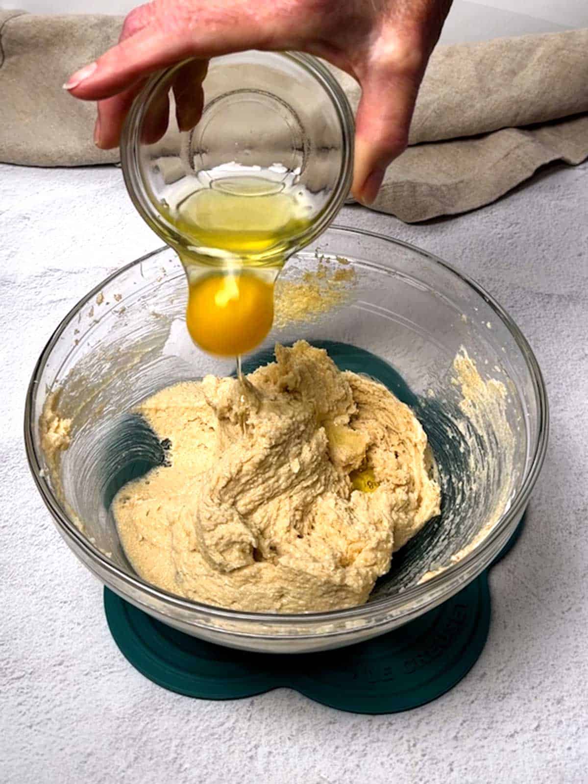 Adding an egg to the cookie dough.