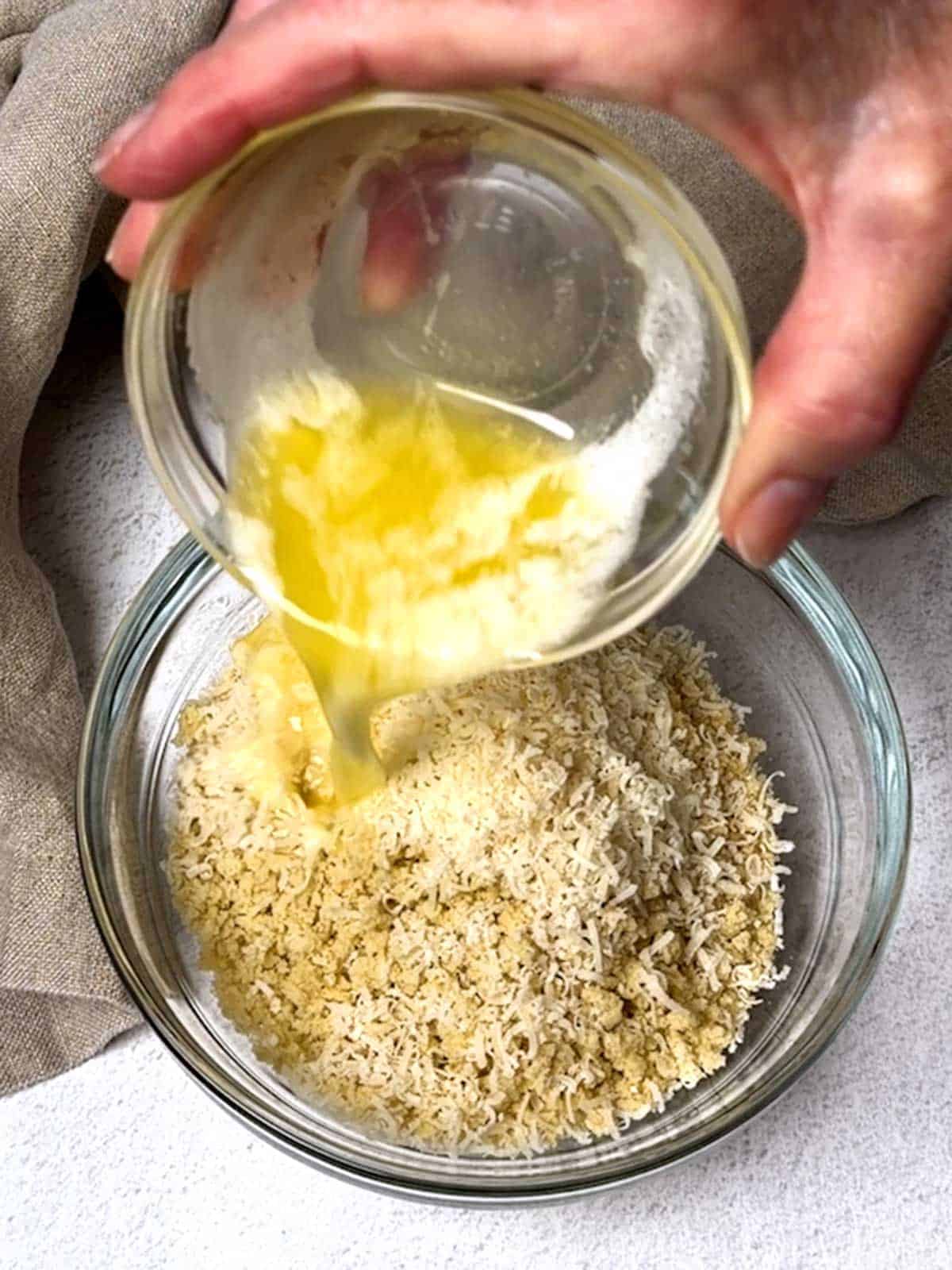 Adding melted butter to Panko and Parmesan cheese.