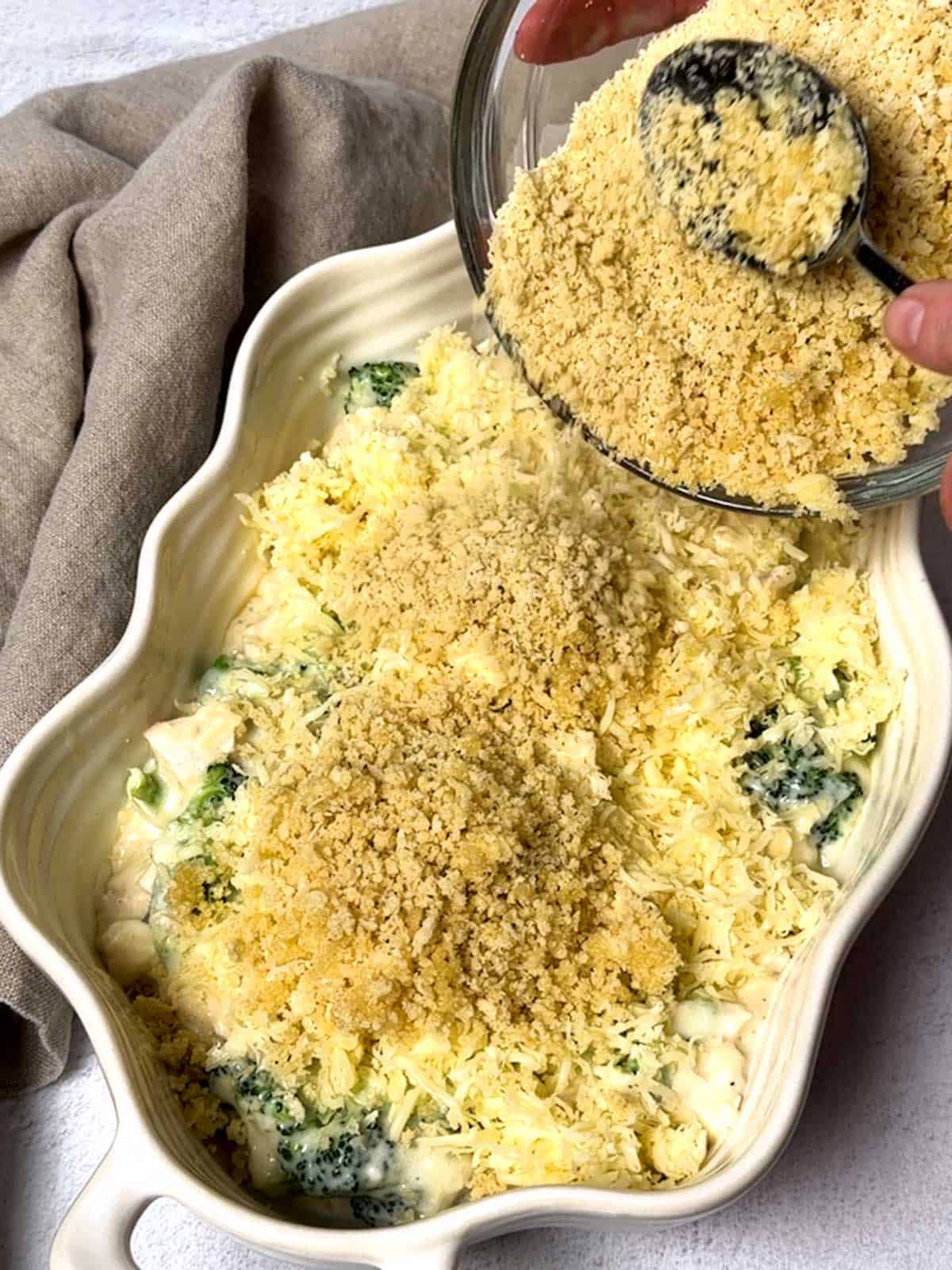 Adding the Panko-Parmesan topping to the casserole.