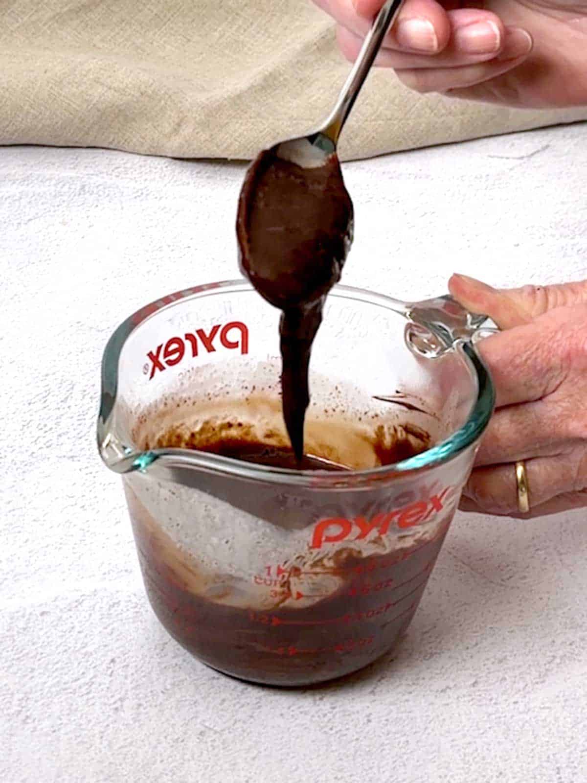 Chocolate ganache dripping from a spoon.