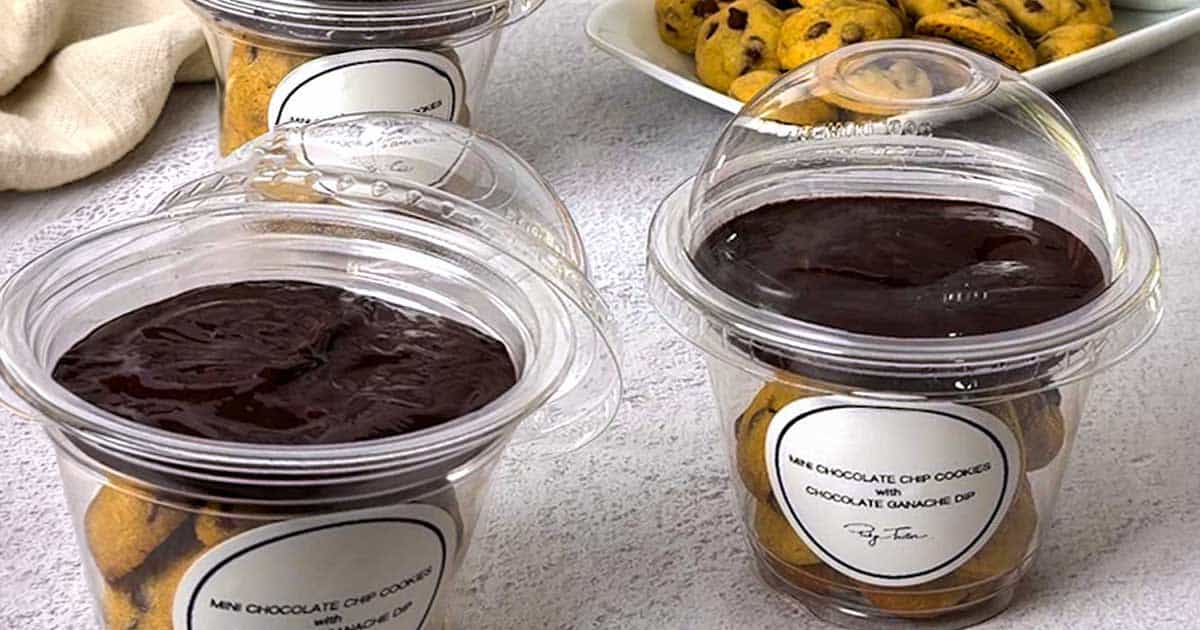 Mini chocolate chip cookies with chocolate ganache in a clear plastic dome cup.