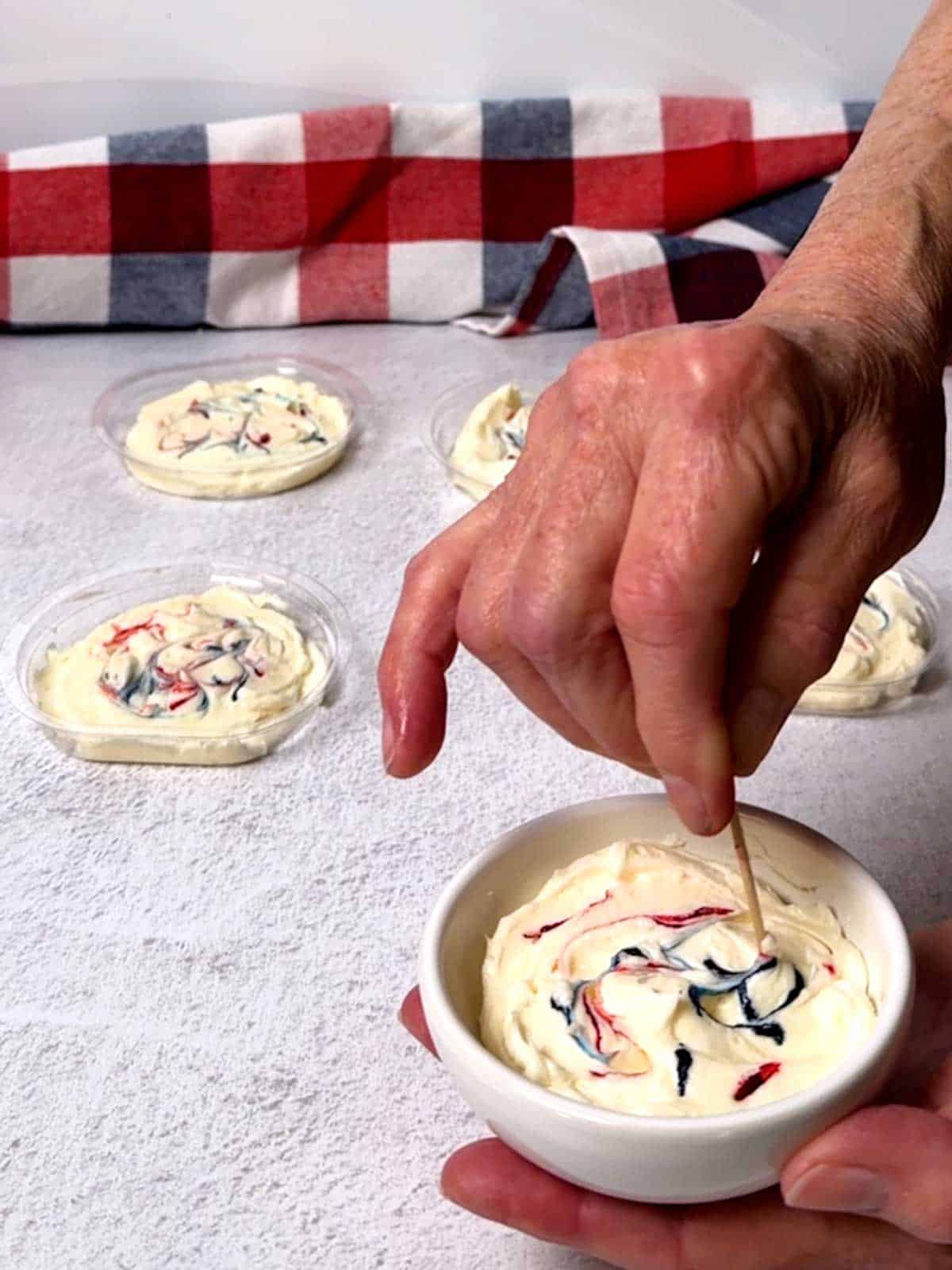 Swirling red and blue gel food color in the marshmallow creme dip.