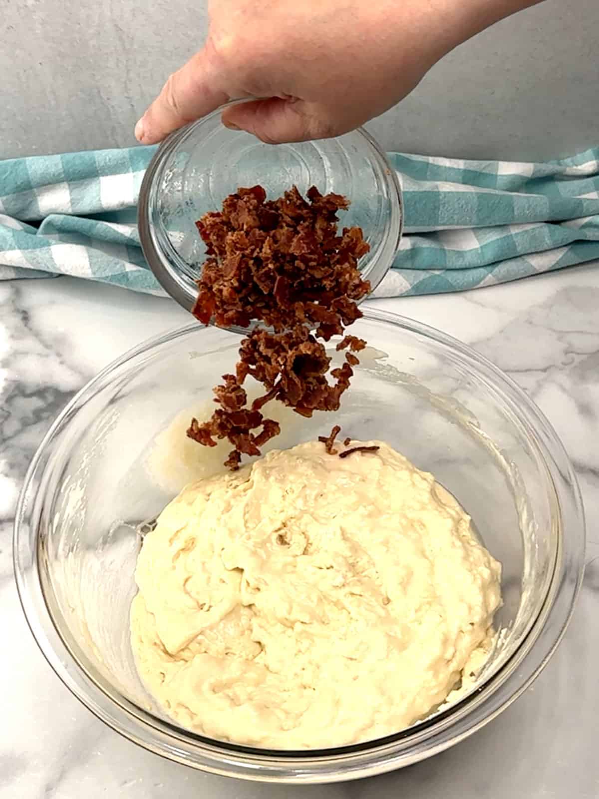 folding in cooked and crumbled bacon