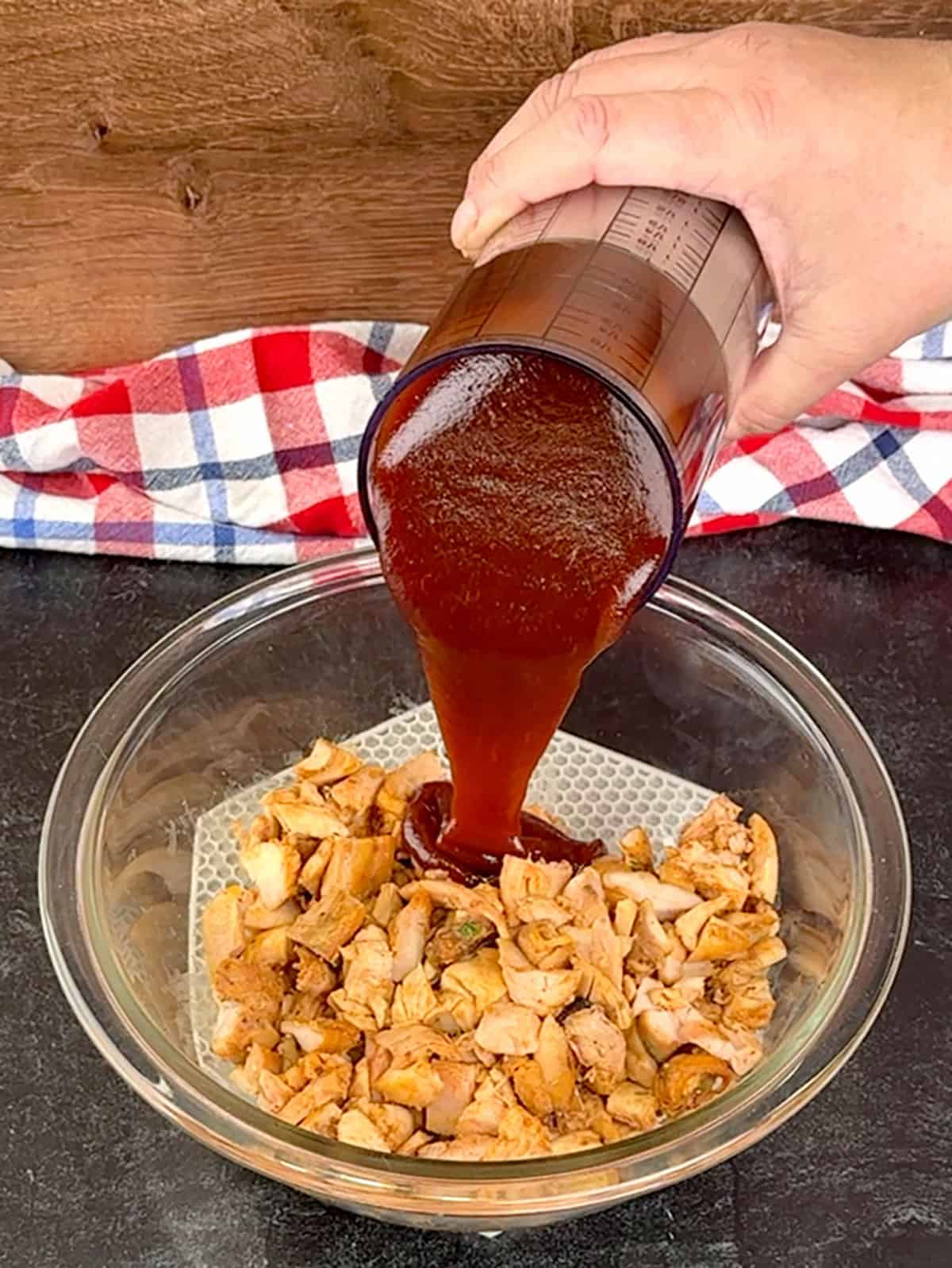 pouring sauce over chicken