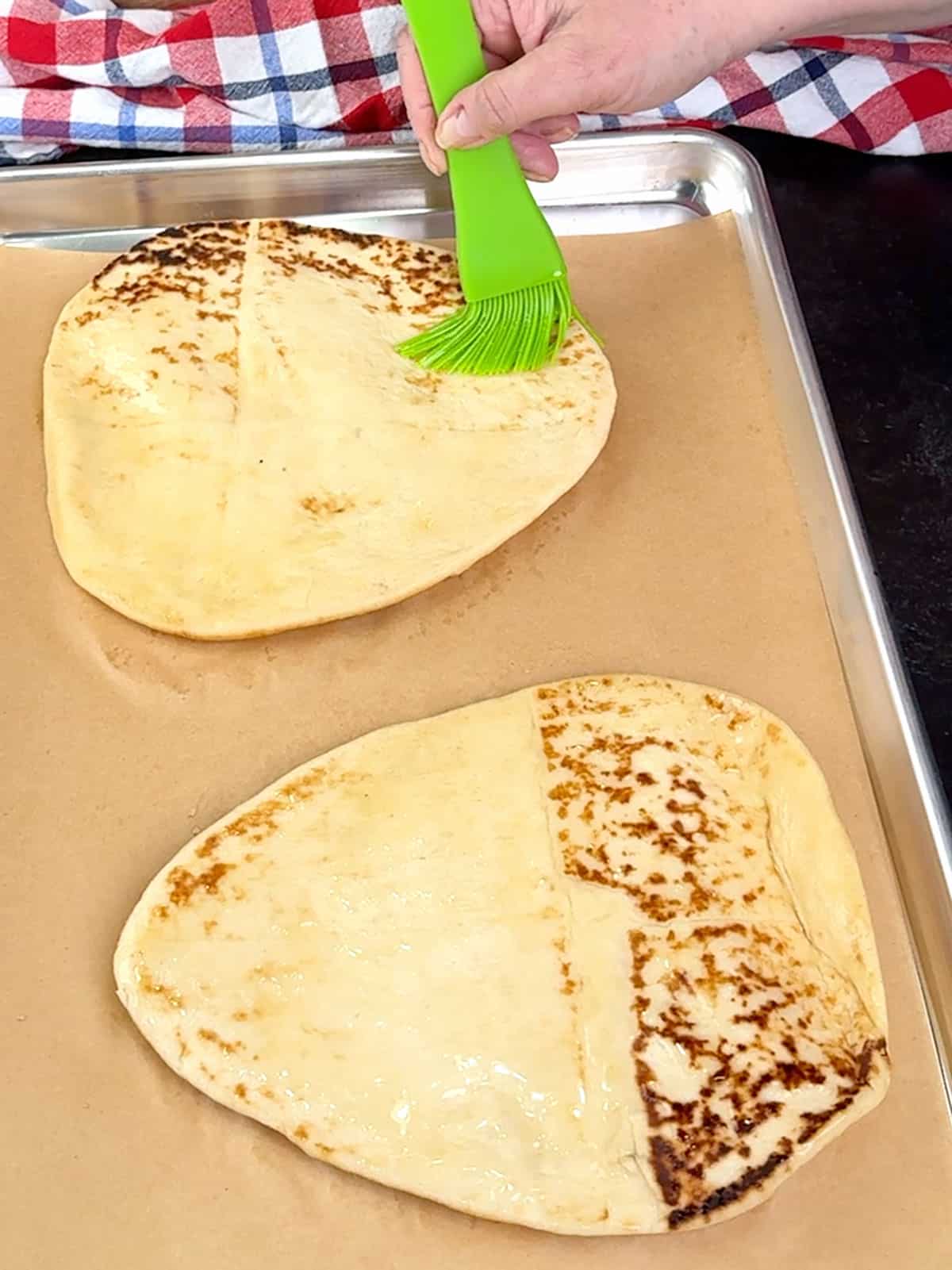 brushing naan with olive oil