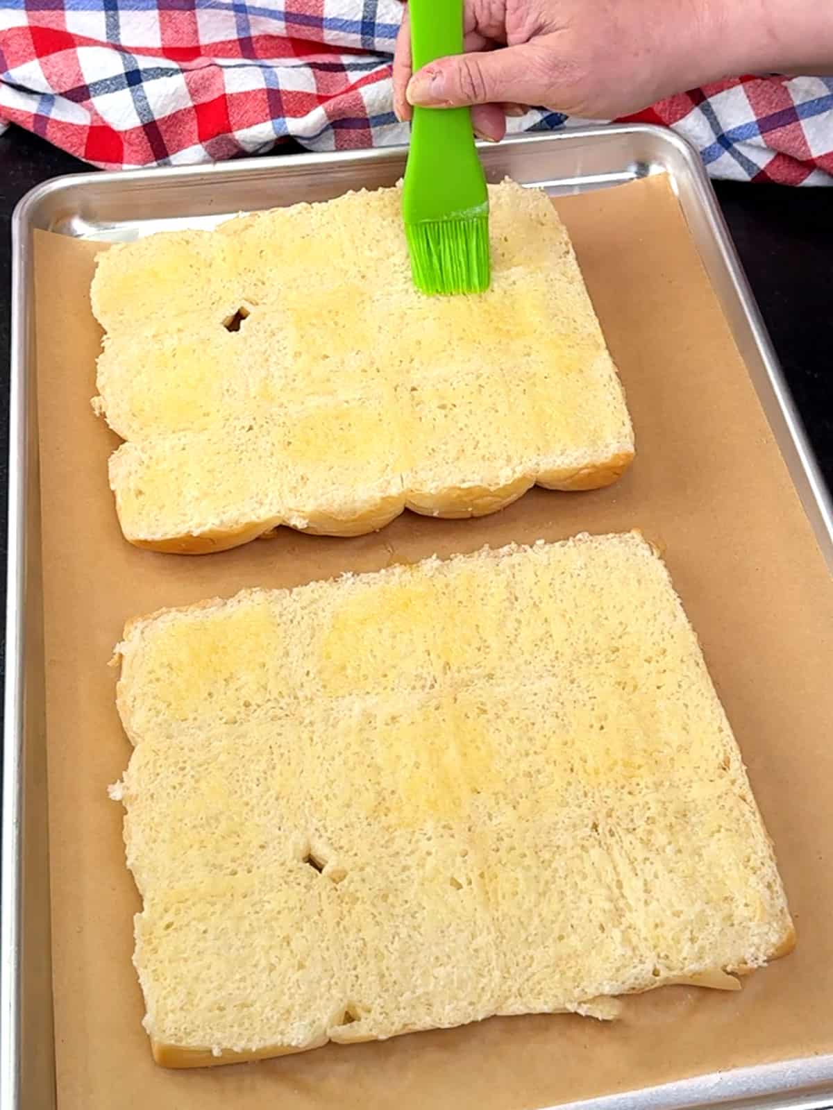 brushing melted butter on slider bun halves