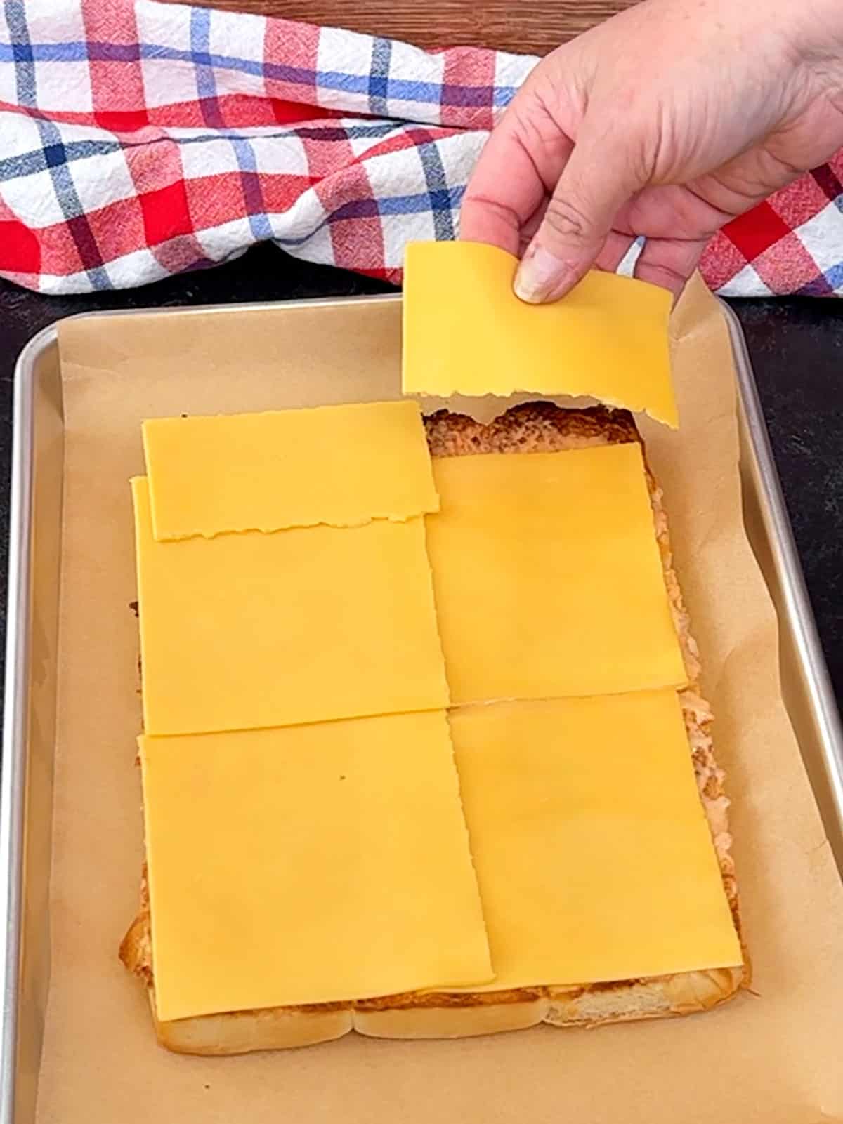 placing bottom layer of cheese on slider buns