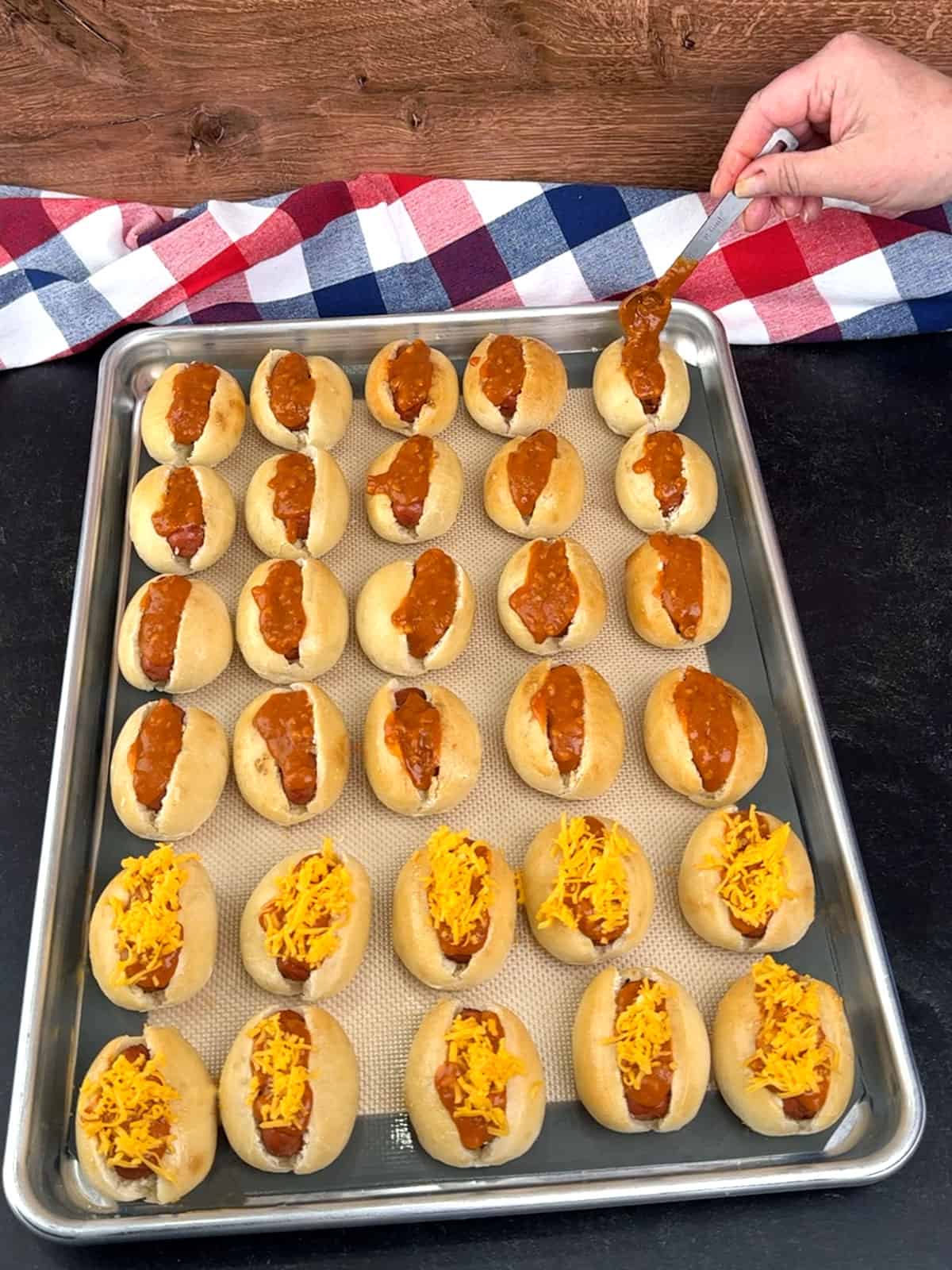 topping Lit'l Smokies with chili and cheese