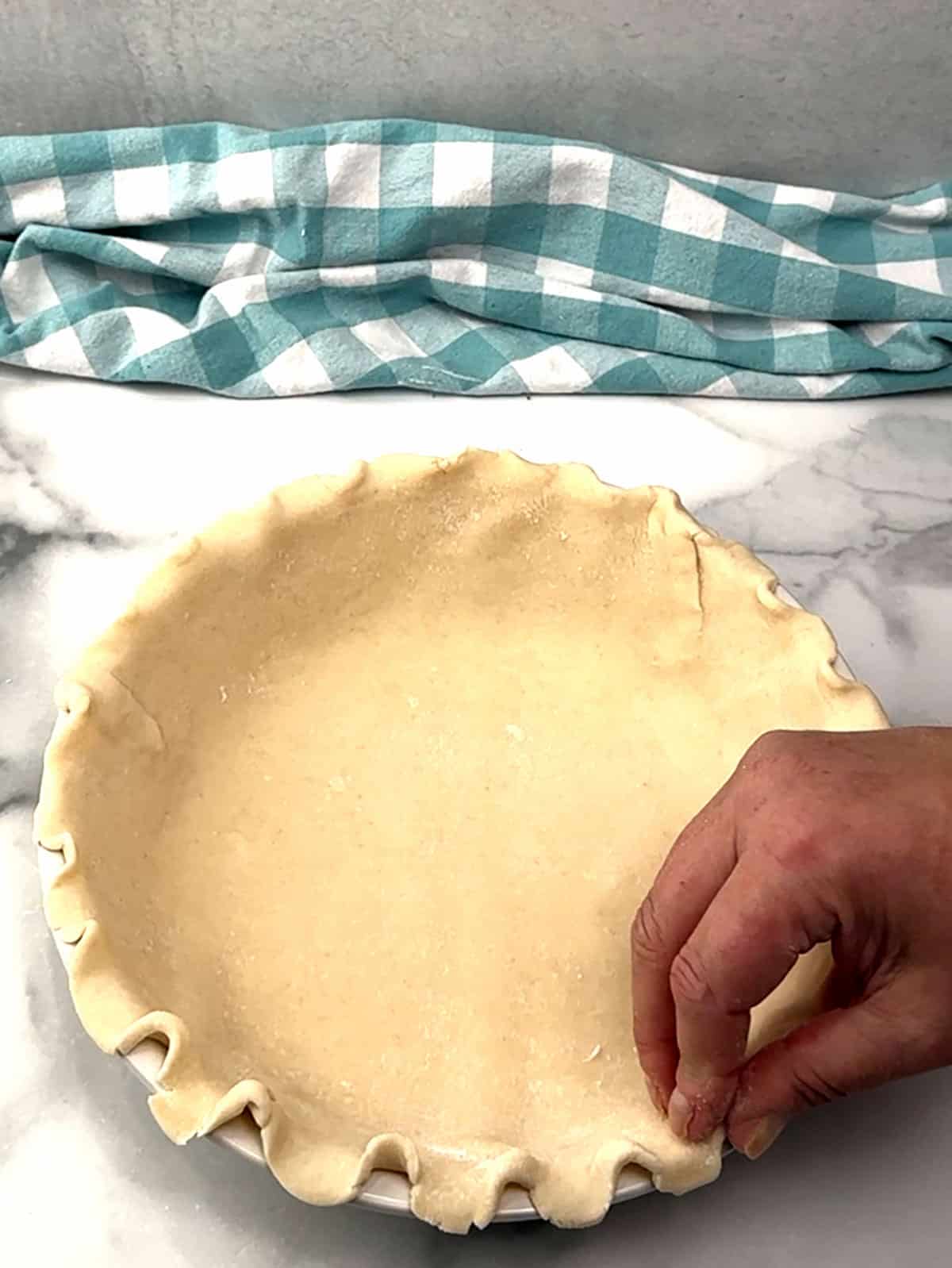 placing crust into pie plate and crimping edges