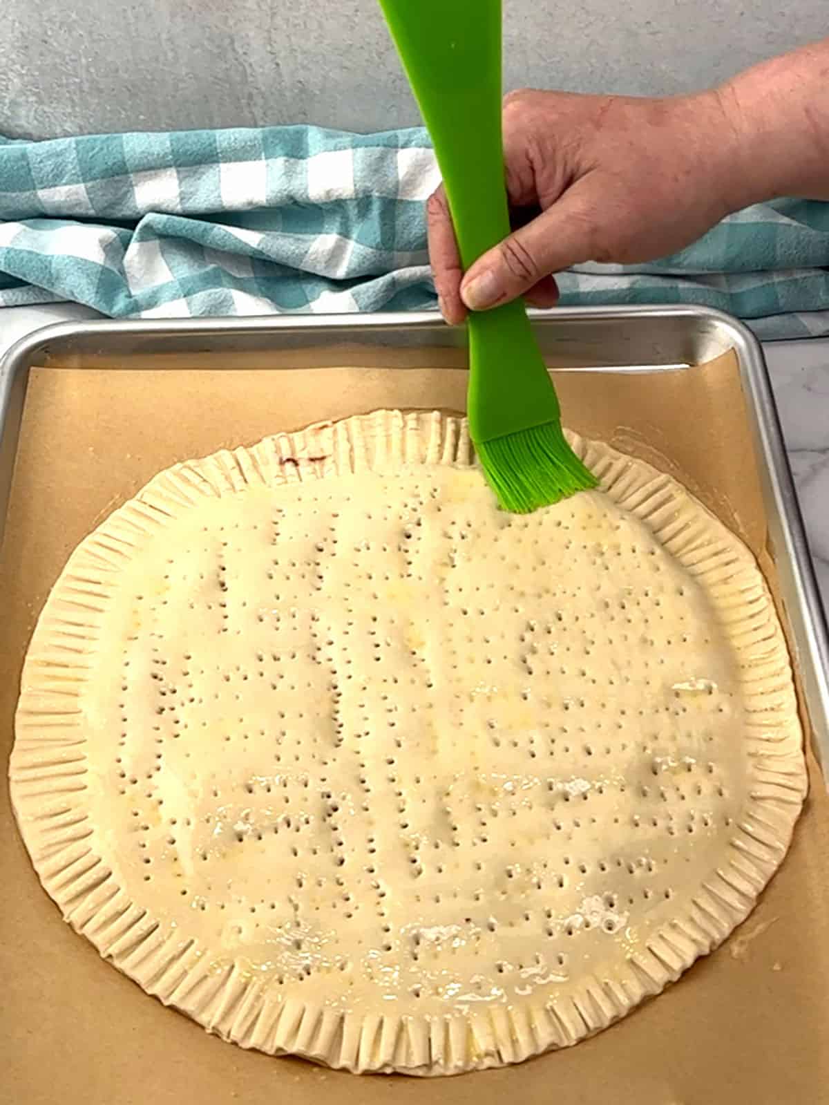 brushing egg wash over top