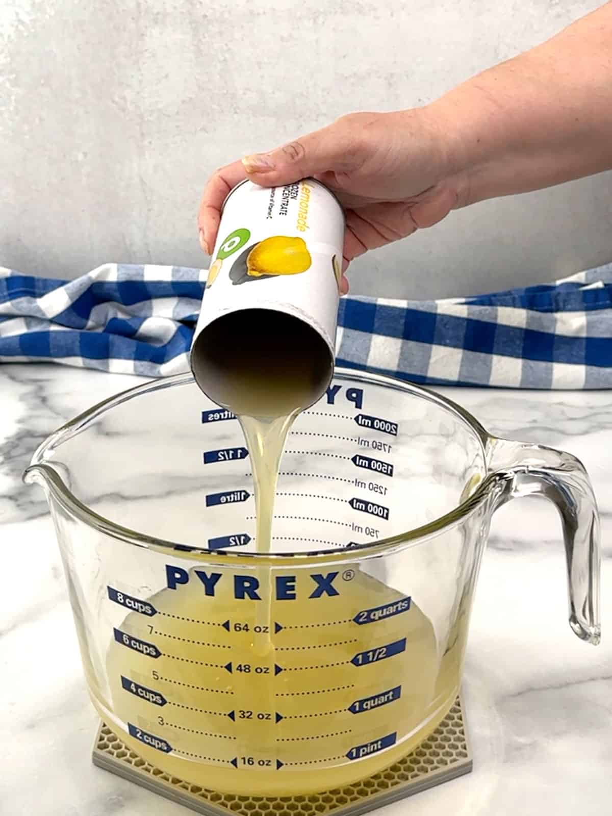 pouring lemonade concentrate into measuring cup
