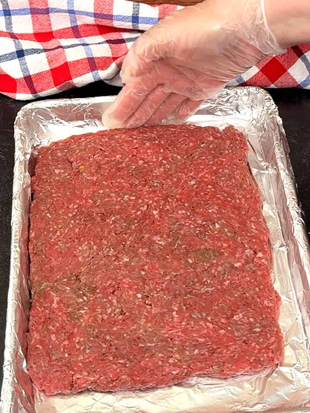 placing shaped prepared meat on baking pan