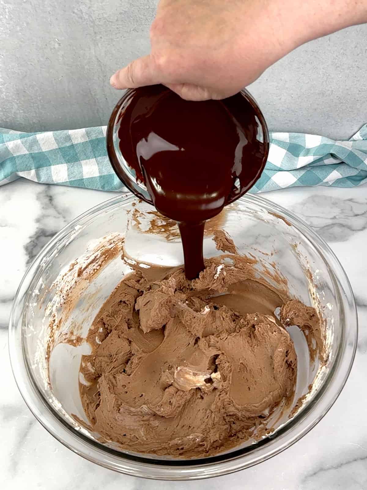 adding melted chocolate and vanilla extract to cheesecake filling