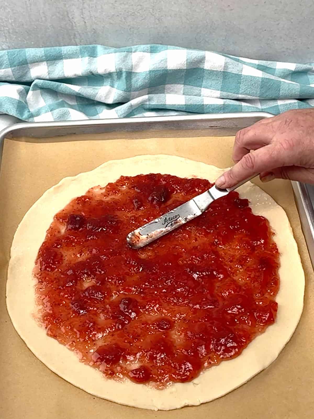 spreading jam over crust