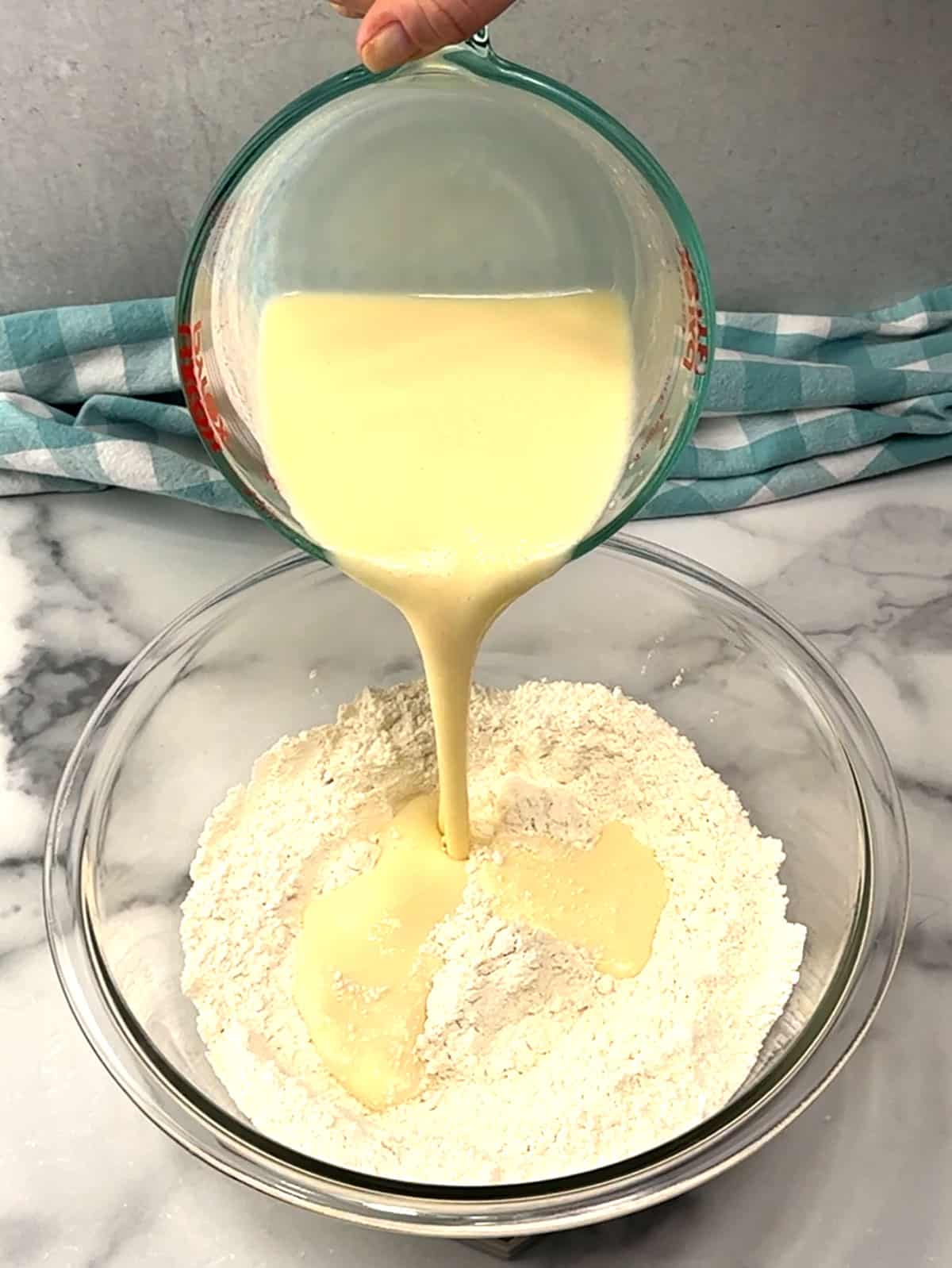 pouring wet ingredients into dry