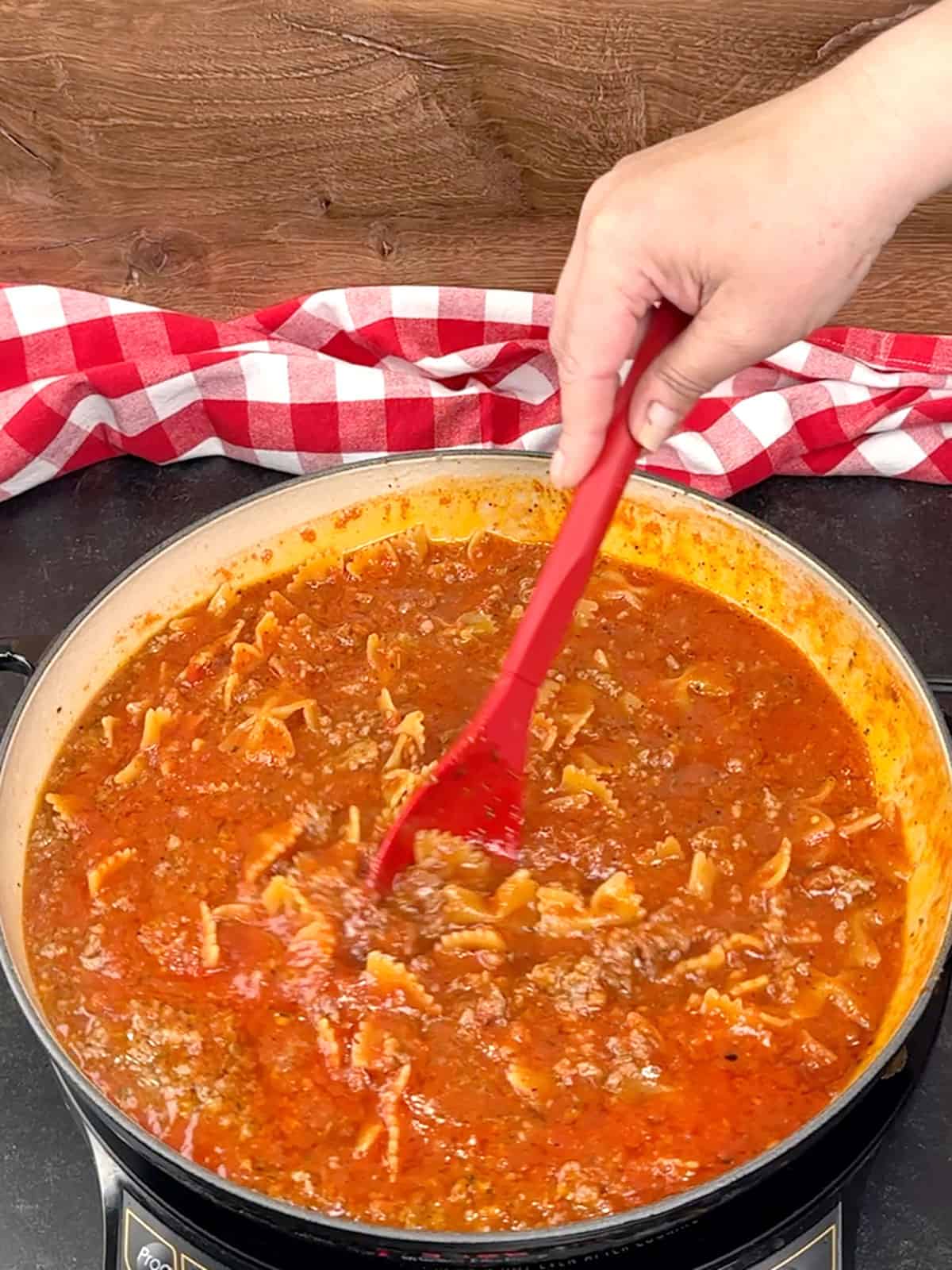 stirring pasta as it cooks