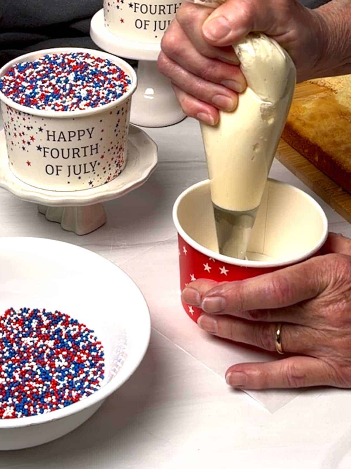 Piping frosting into the bottom of the container.