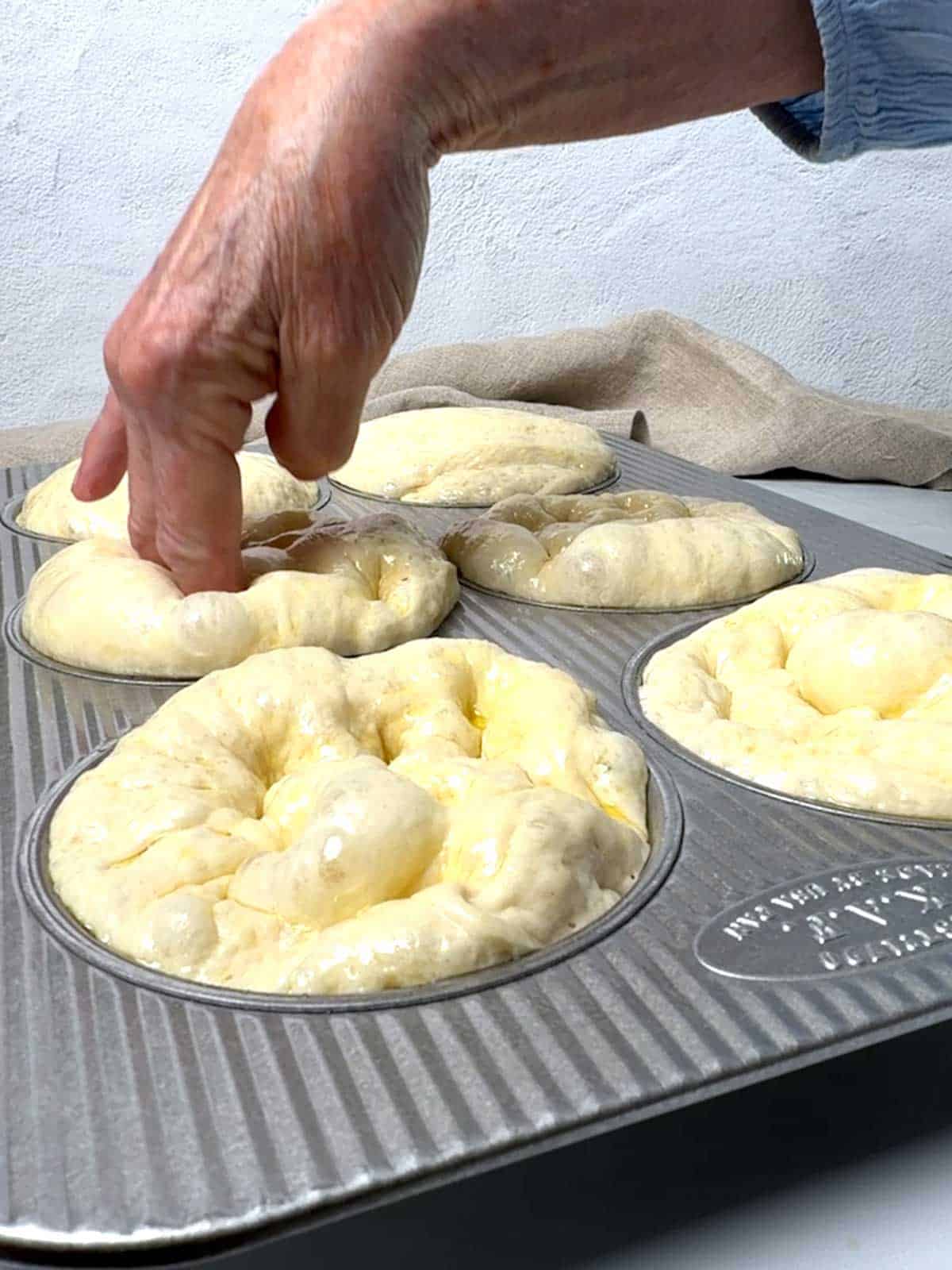 Dimpling the focaccia buns.