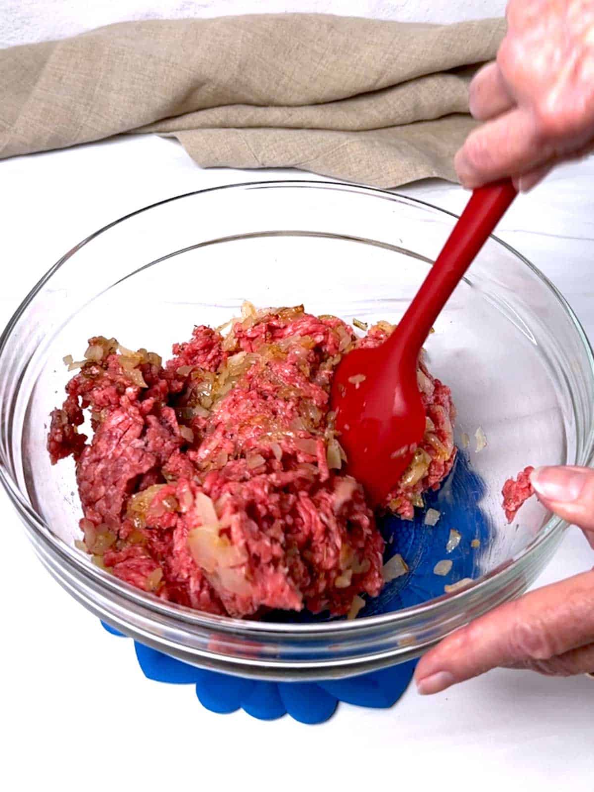 Mixing the beef mixture in a bowl.