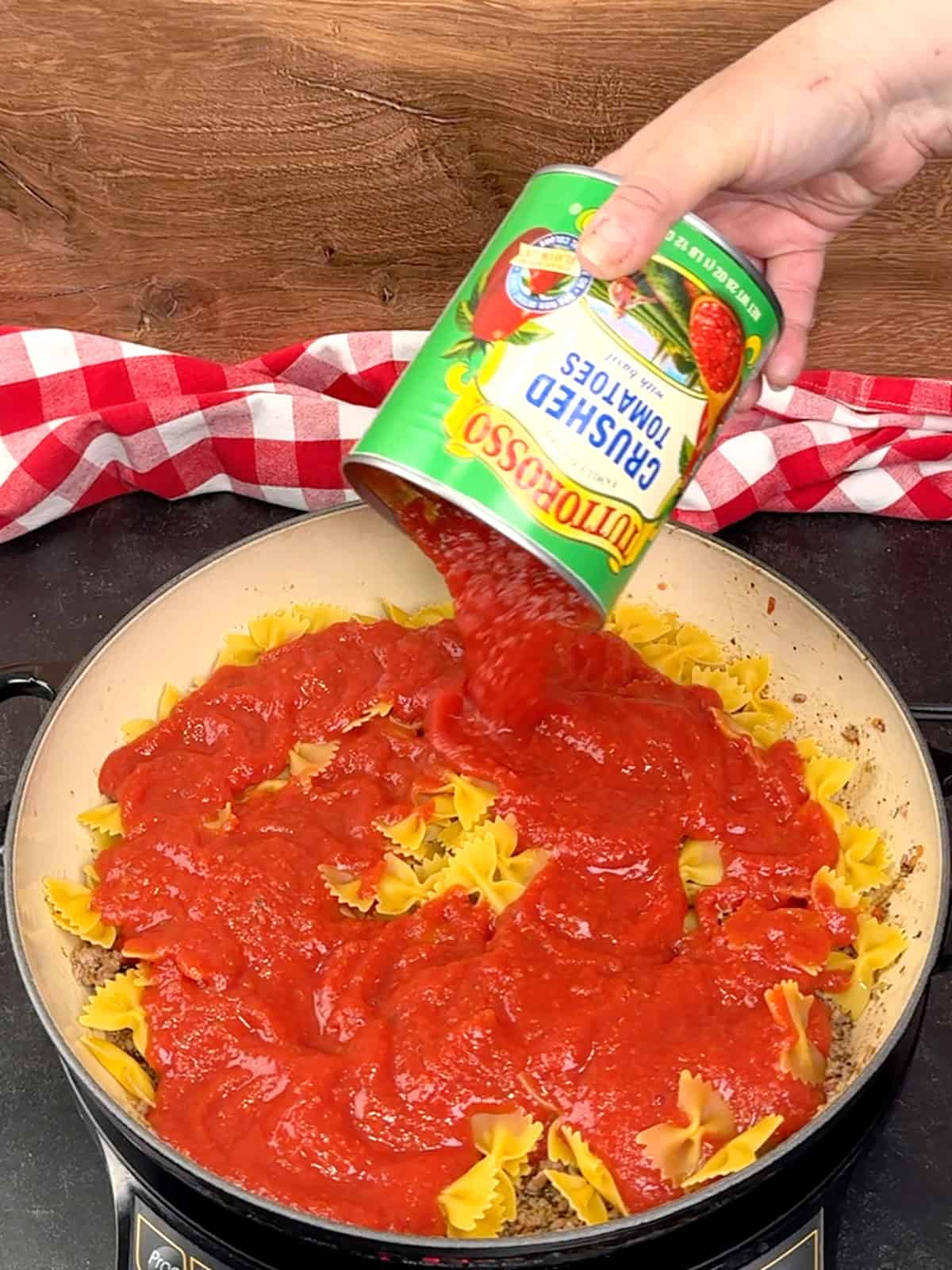 adding crushed tomatoes and water