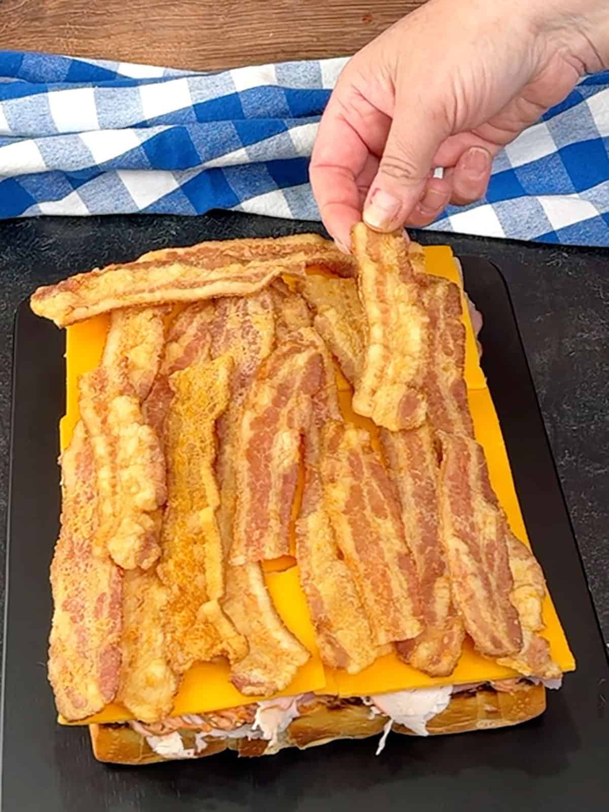 layering bacon on top of cheddar cheese