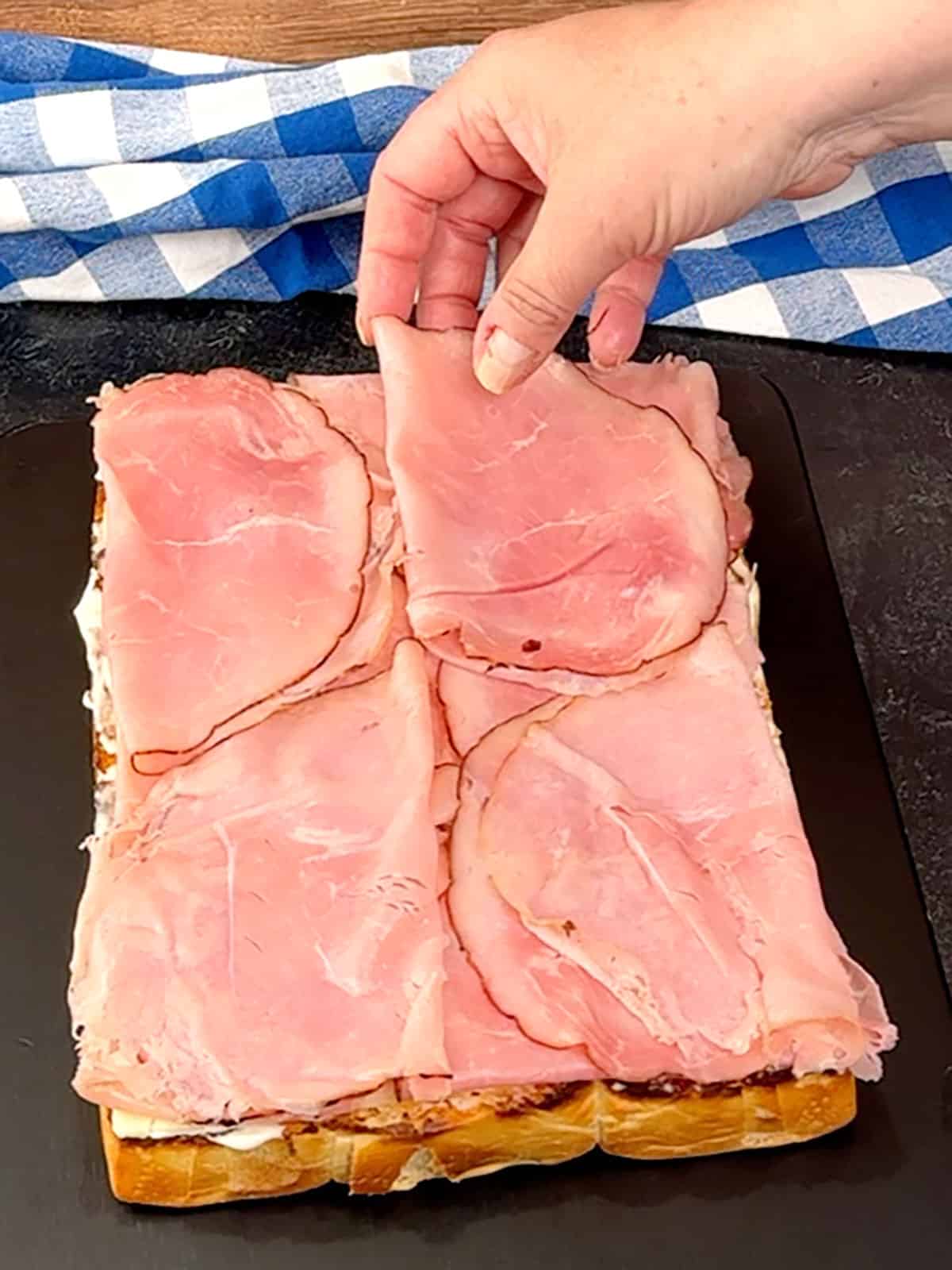 placing ham on top of Swiss cheese
