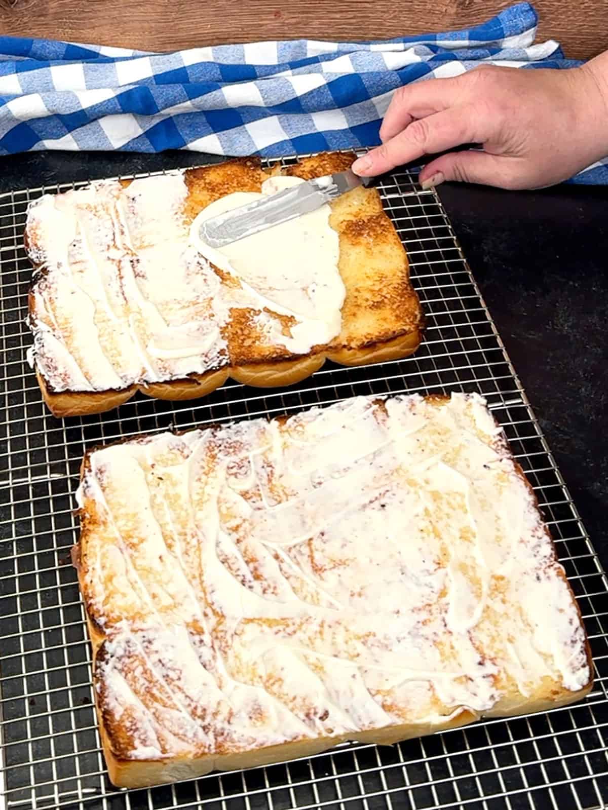 spreading mayo over toasted cooled rolls