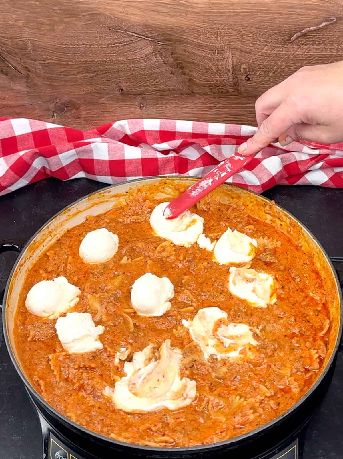 gently spreading dollops of ricotta