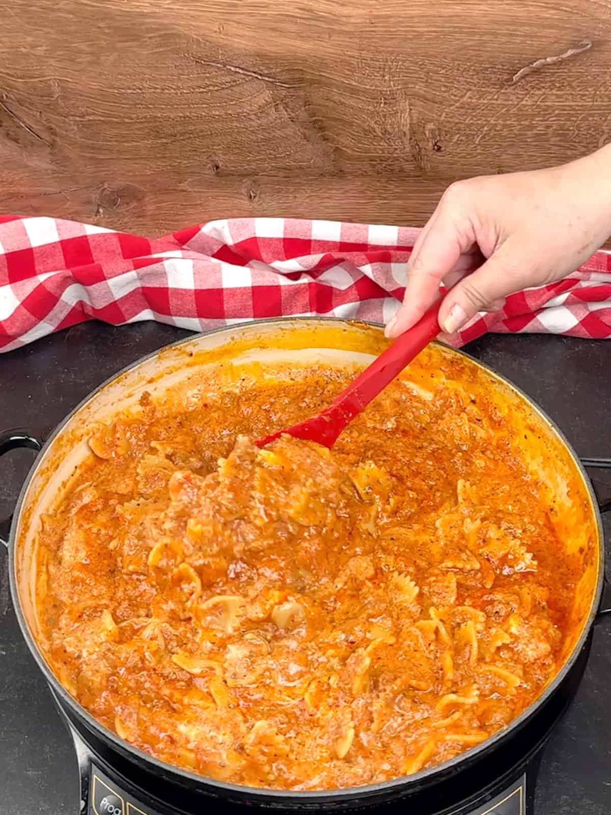 stirring cheeses into the cooked pasta and sauce