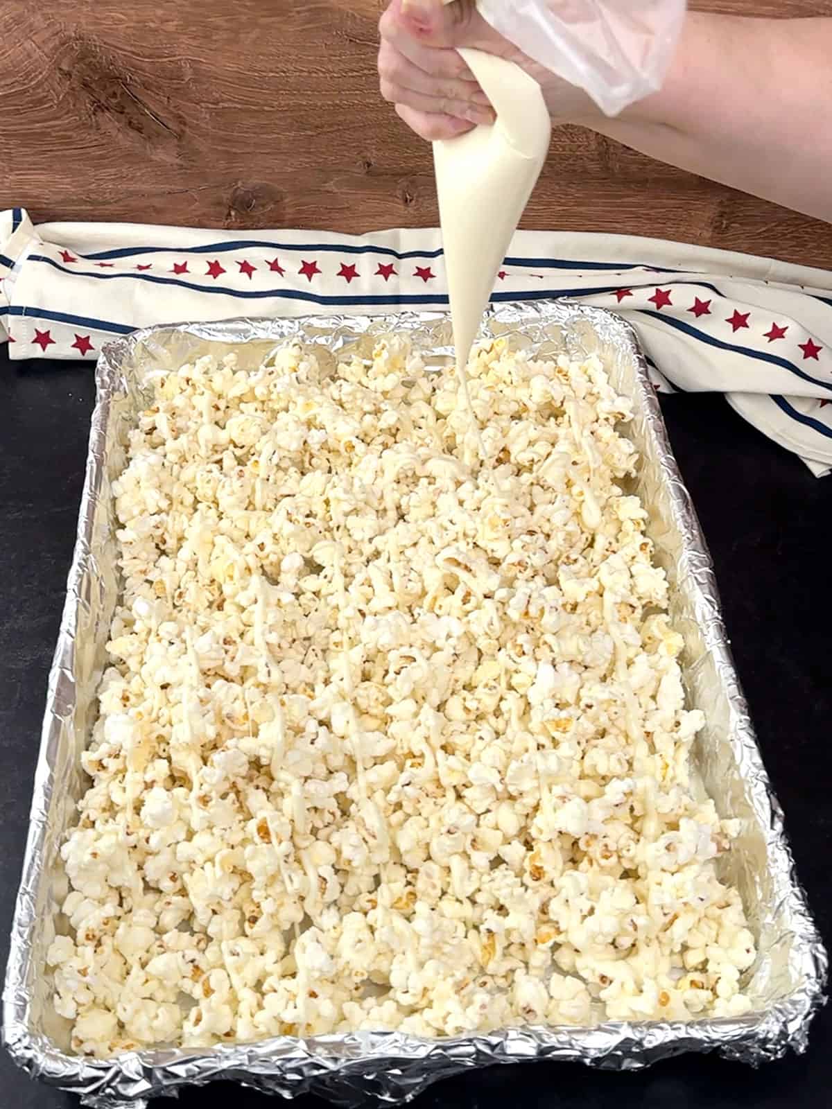 drizzling white chocolate over popcorn