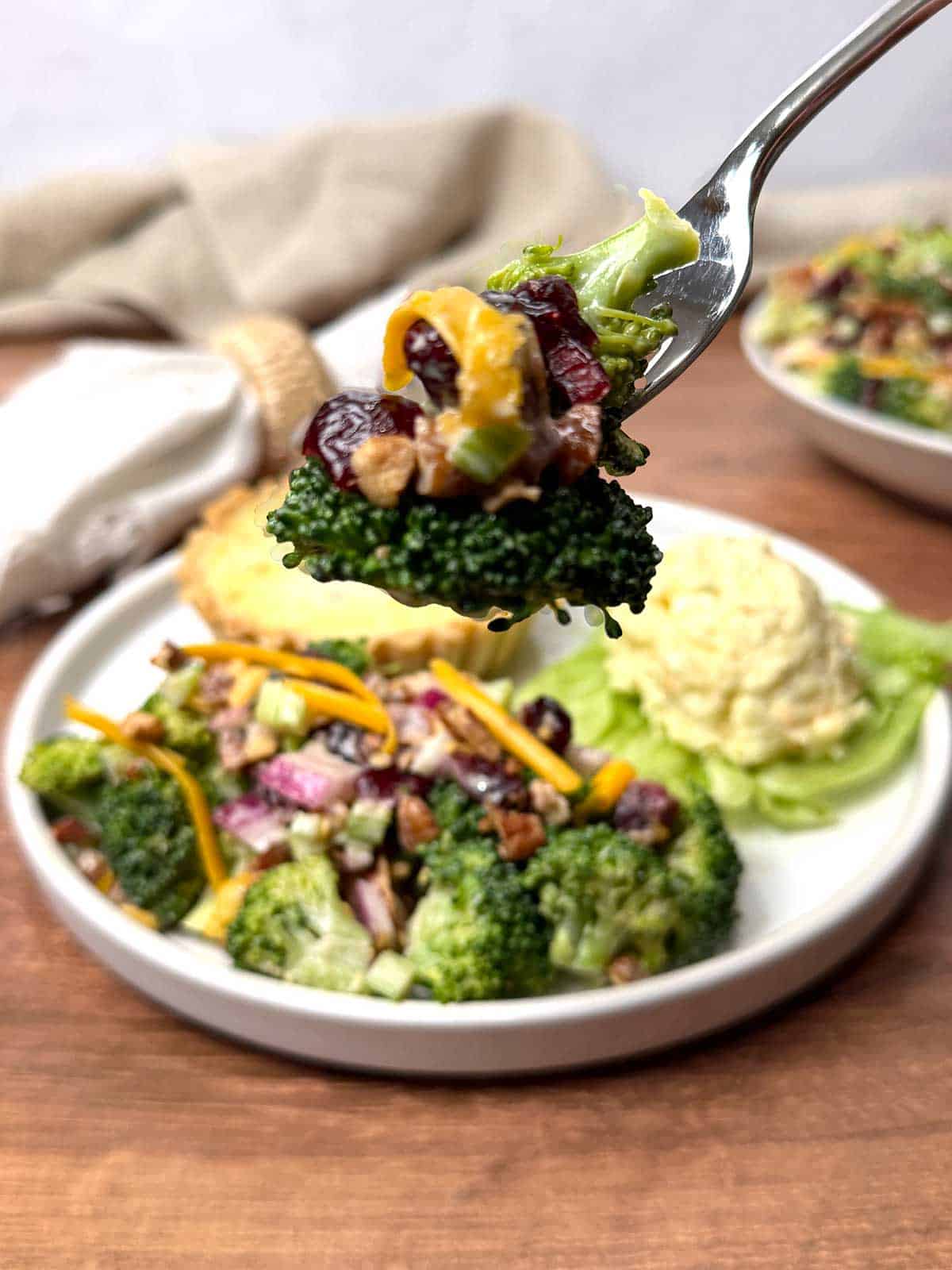 Broccoli salad on a fork.